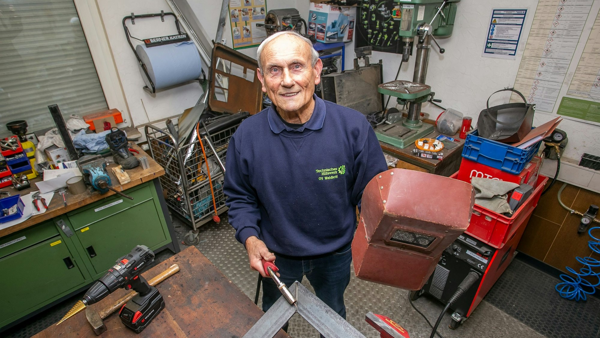 Eckhard Bujack steht in der Schirrmeisterei und hält ein Schweißgerät in der Hand.