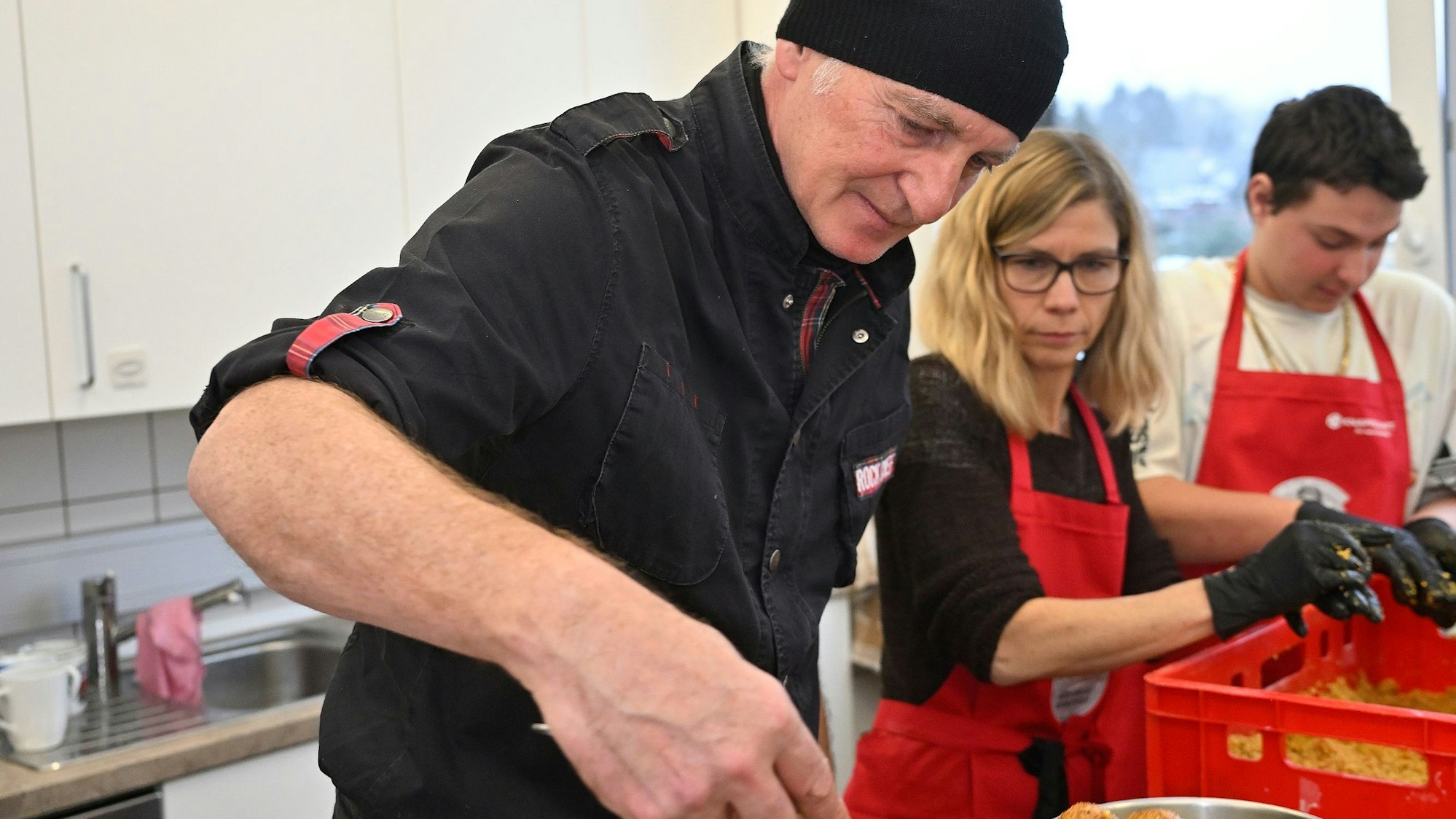 Mehrere Menschen frittieren Falafe in einem Tiopf.