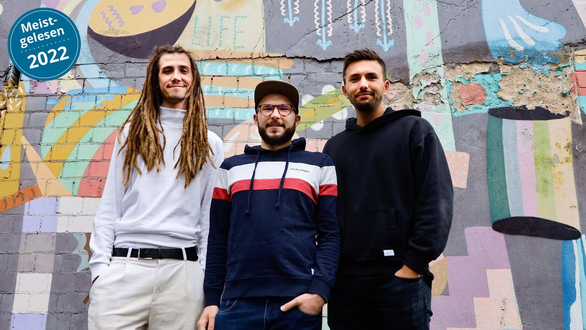 Carlo Stein, David Tochtenhagen und Patrick Schumm stehen vor einer bemalten Hauswand.