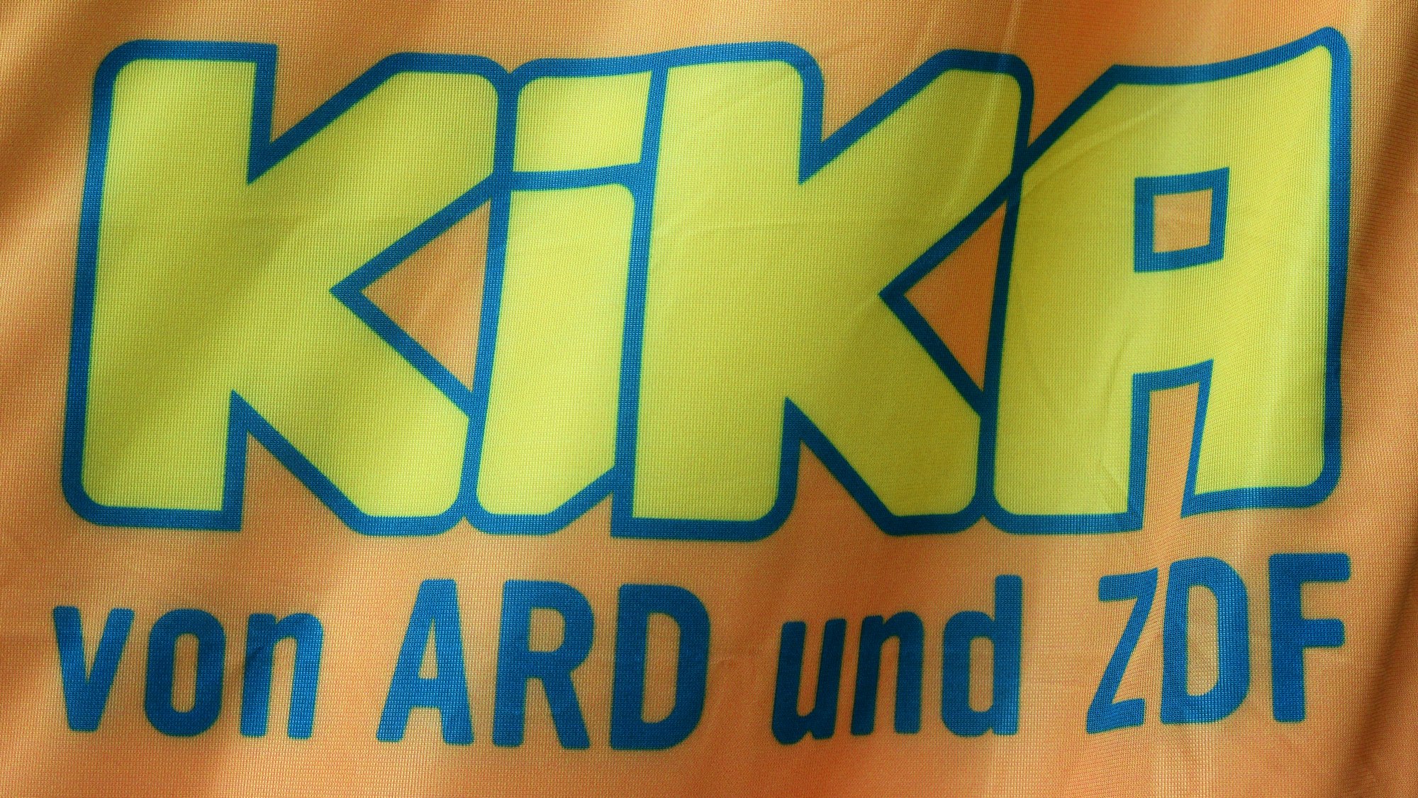 Das Logo von KiKA, dem Kinderkanal von ARD und ZDF, ist auf einem Stoff abgebildet.