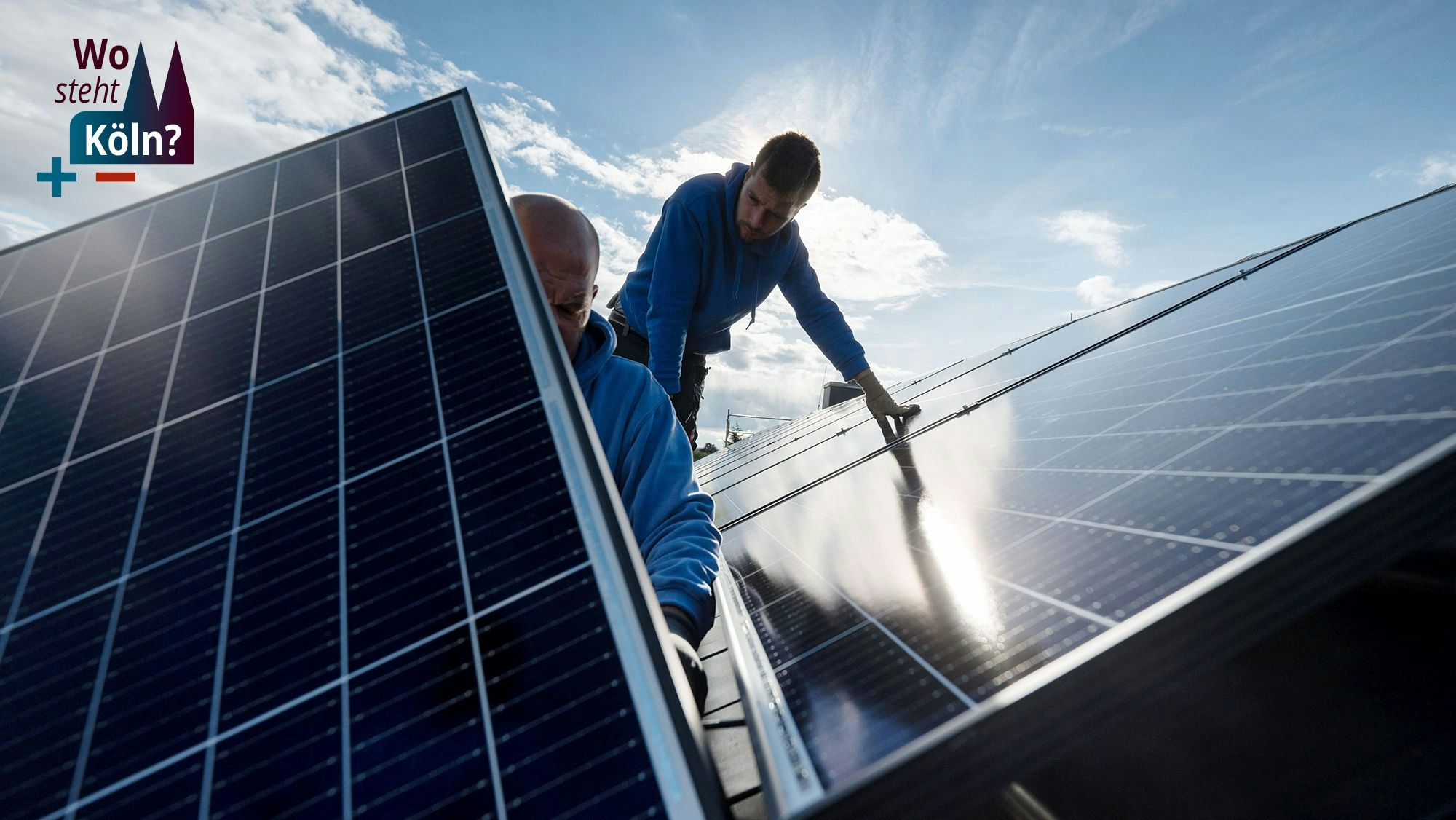 Techniker montieren Photovoltaikmodule auf dem Dach eines Wohnhauses.