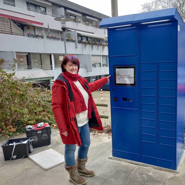 Amtsleiterin Brigitte Gutendorf steht neben dem blauen Ausweis-Automaten vor dem Rathaus.