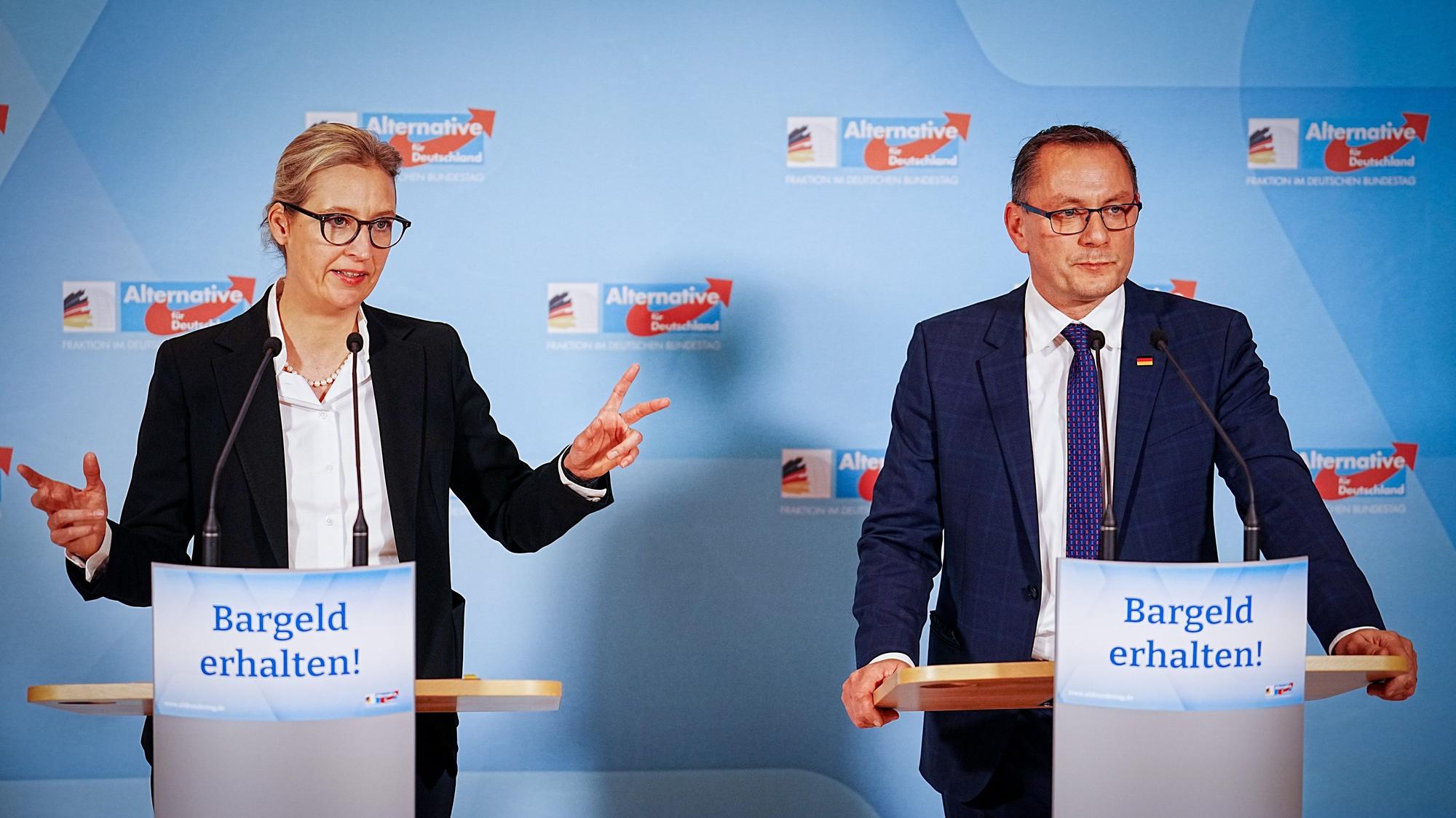 Alice Weidel (l.) und Tino Chrupalla bei ihrem Pressestatement – vor ihren Rednerpulten kleben Zettel mit der Aufschrift „Bargeld erhalten“