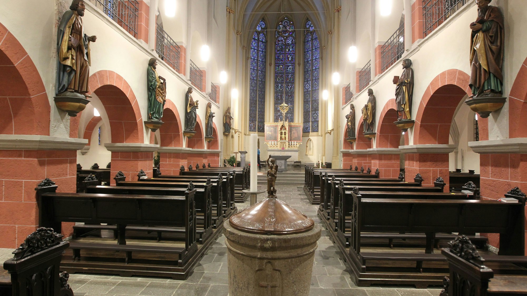 Der Innenraum der Siegburger Kirche St. Servatius mit seinen hölzernen Kirchenbänken ist zu sehen.