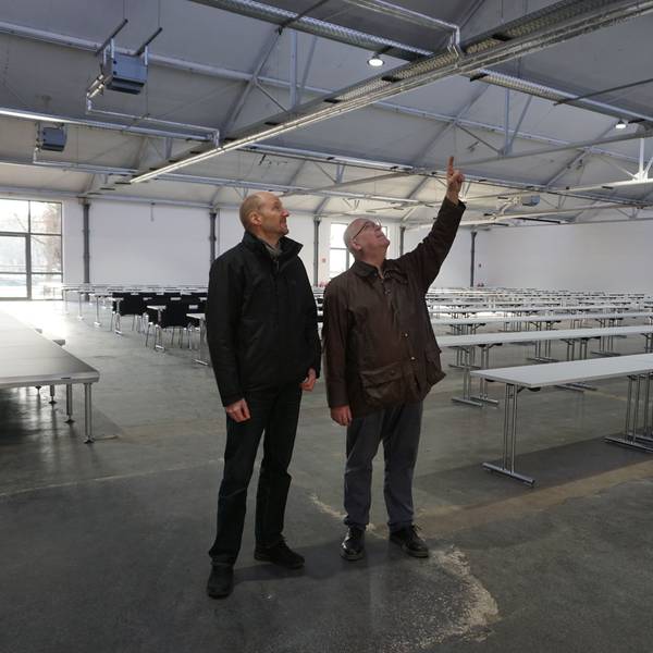 Zwei Männer, Jürgen Huthmacher (l.) und Christoph Stolzenberger, schauen sich das Dach der Veranstaltungshalle an.