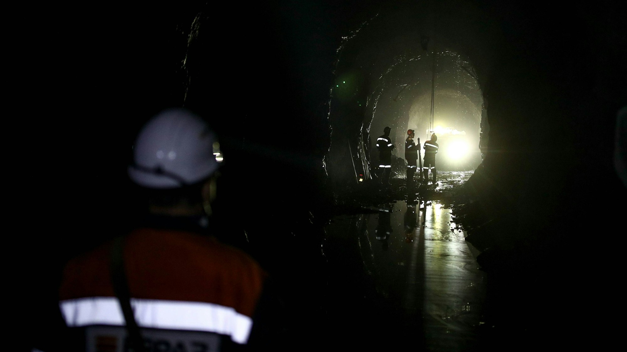Minenarbeiter arbeiten in der Mine von Sheregesh mit Kabeln und Seilen.