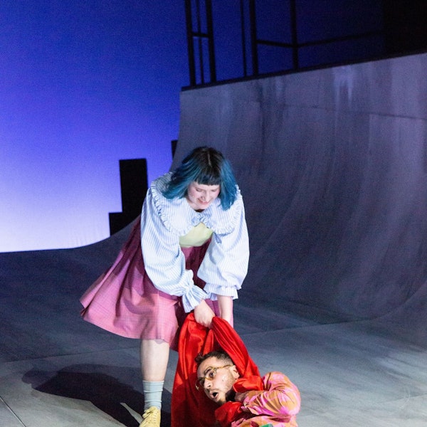 Szene Helges Leben am Schauspiel Köln, ein Mann am Boden wird an seinem roten Schal über die Bühne gezerrt.