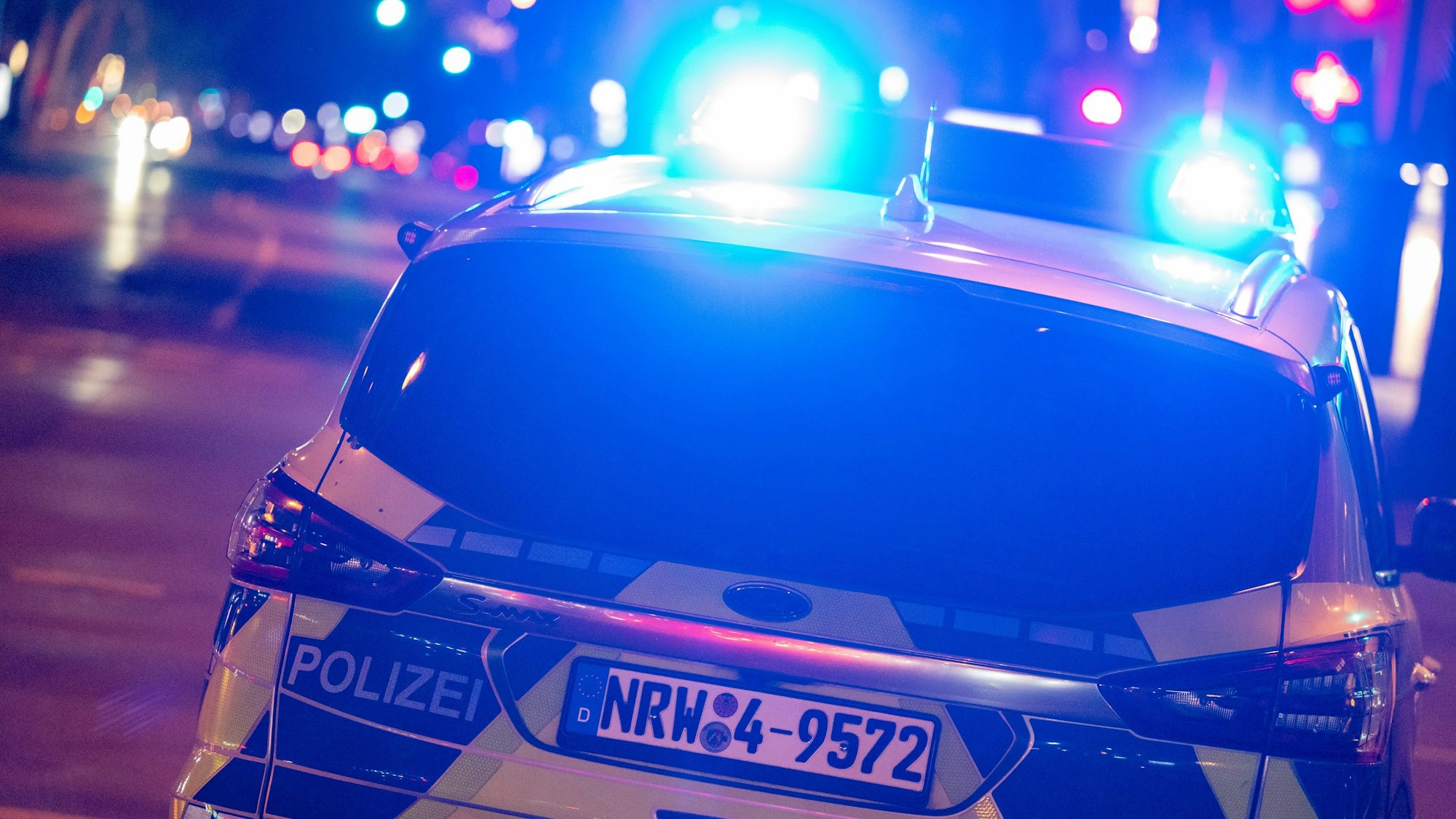 Das Foto zeigt einen Polizeiwagen bei Nacht.