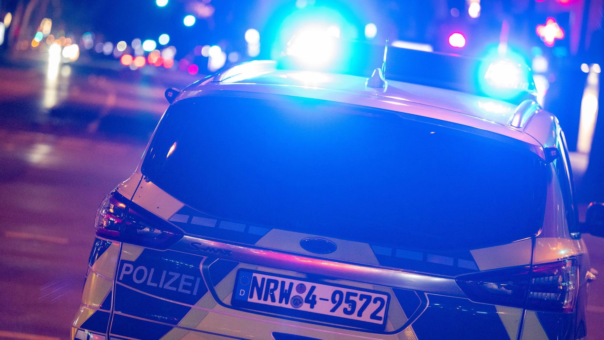 Ein Polizeiauto fährt durch die Nacht.