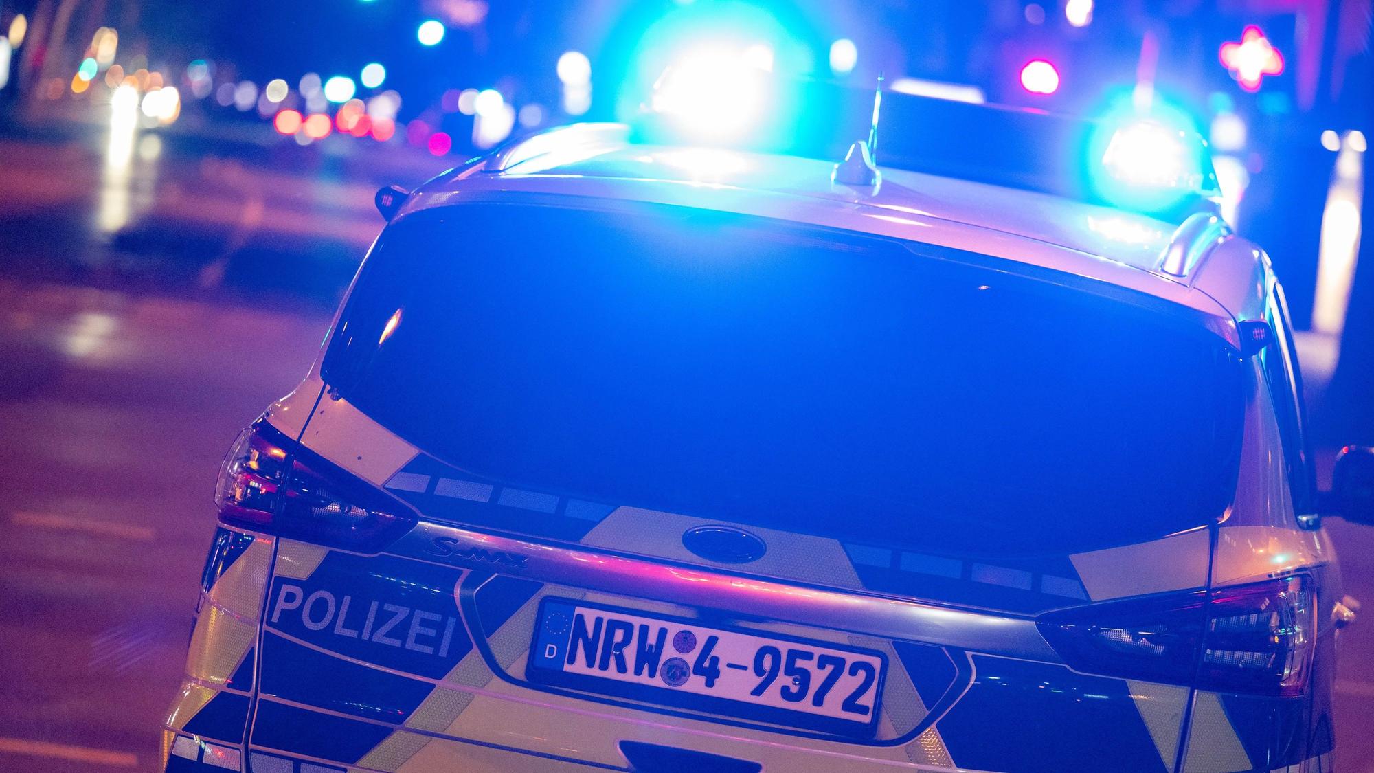 Ein Polizeiauto nachts mit Blaulicht im Einsatz.