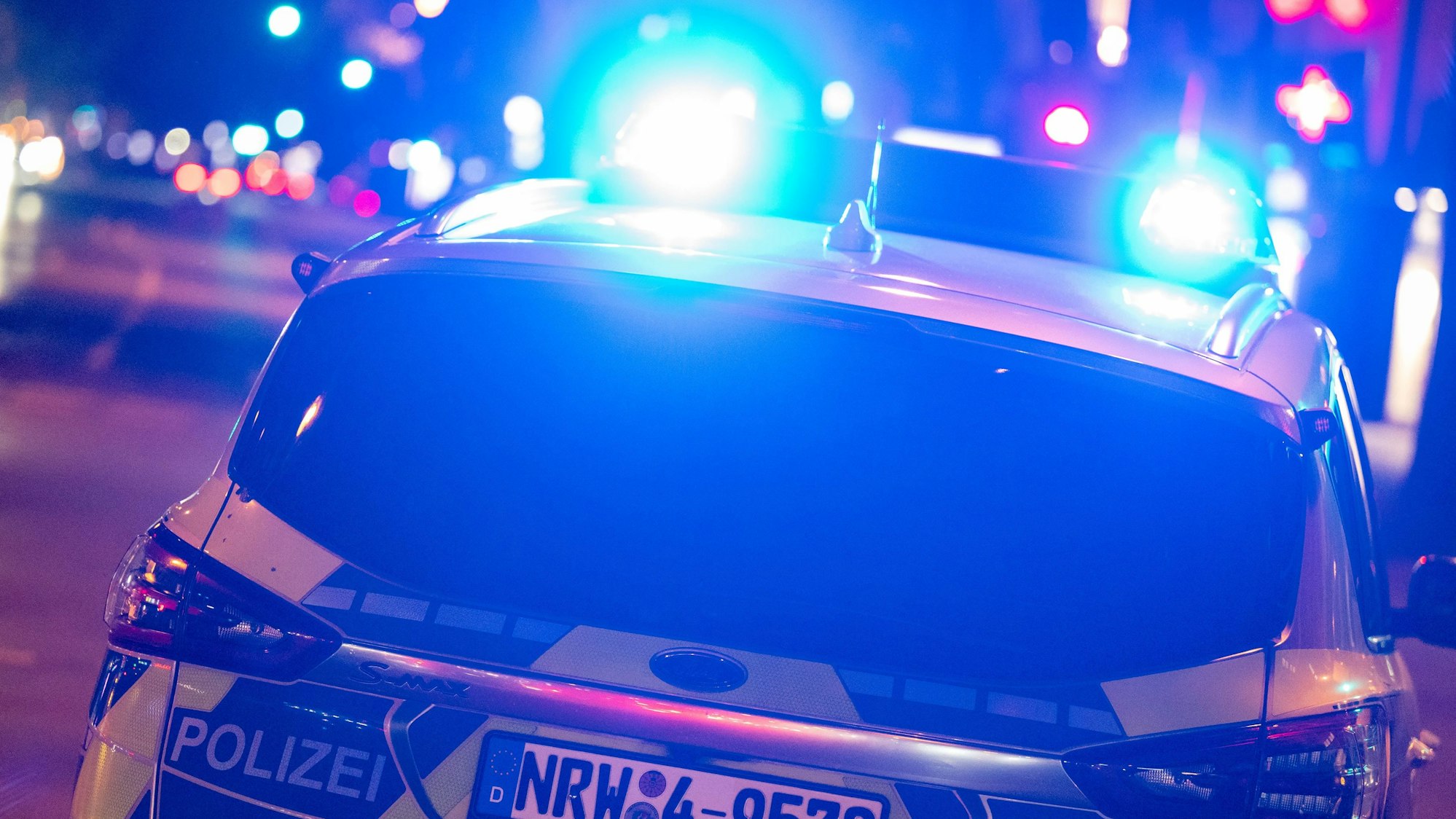 Das Bild zeigt einen Polizeiwagen bei Nacht.