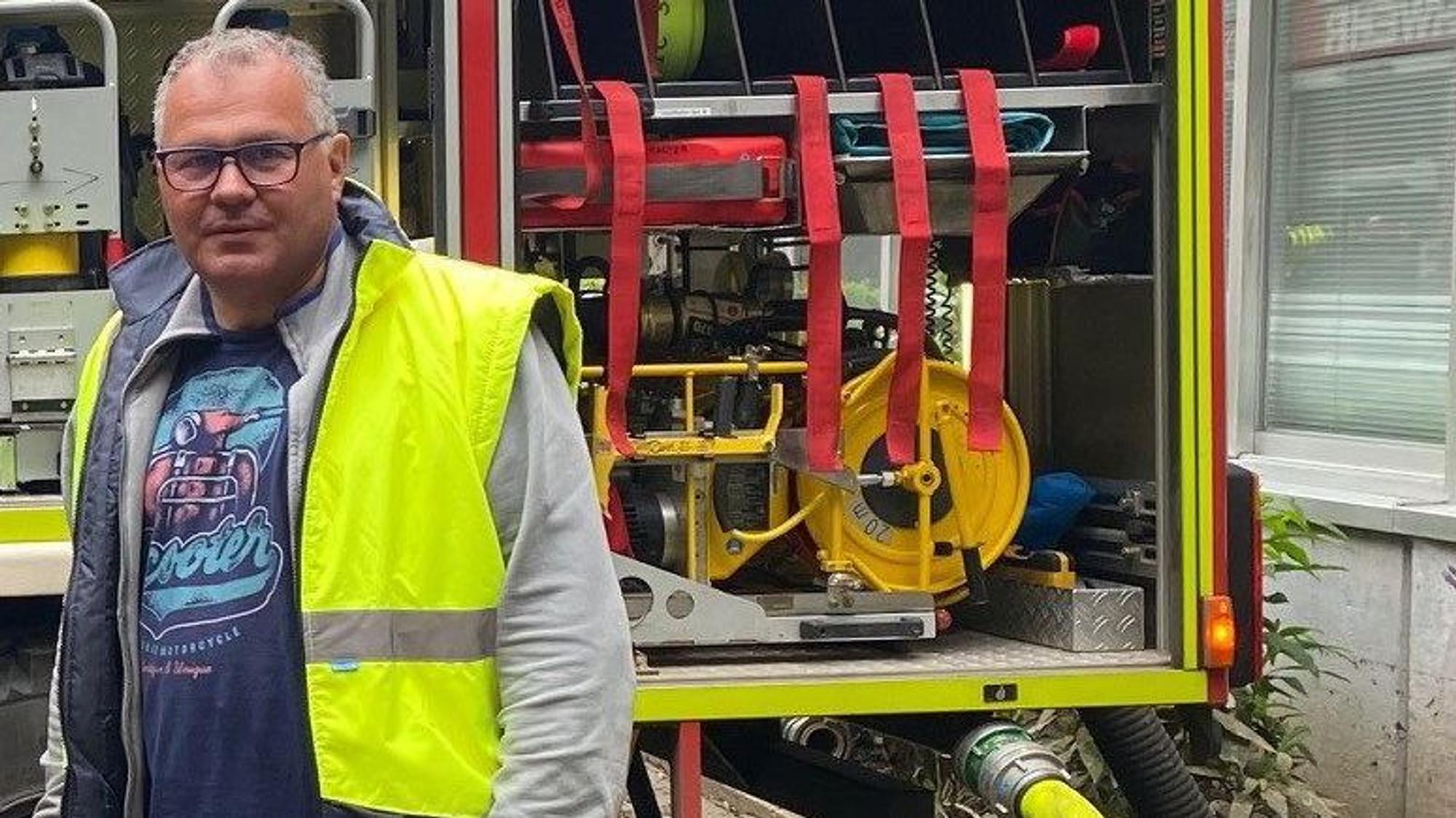 Bürgermeister Frank Steffes steht in gelber Warnweste vor einem Feuerwehrauto.