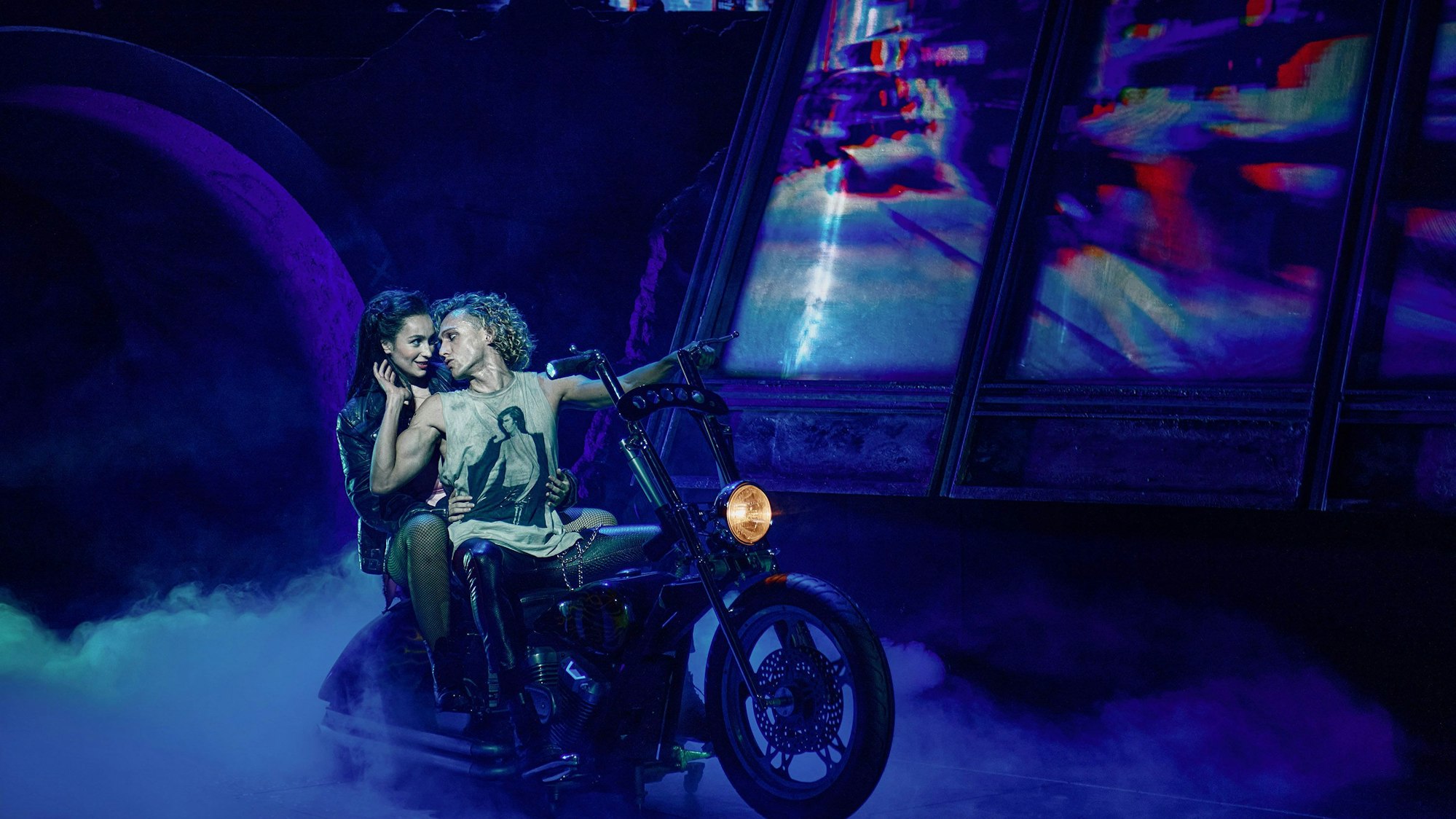 Szene aus dem Musical Bat out of Hell, ein Paar auf einem Motorrad, die Straße ist neblig.