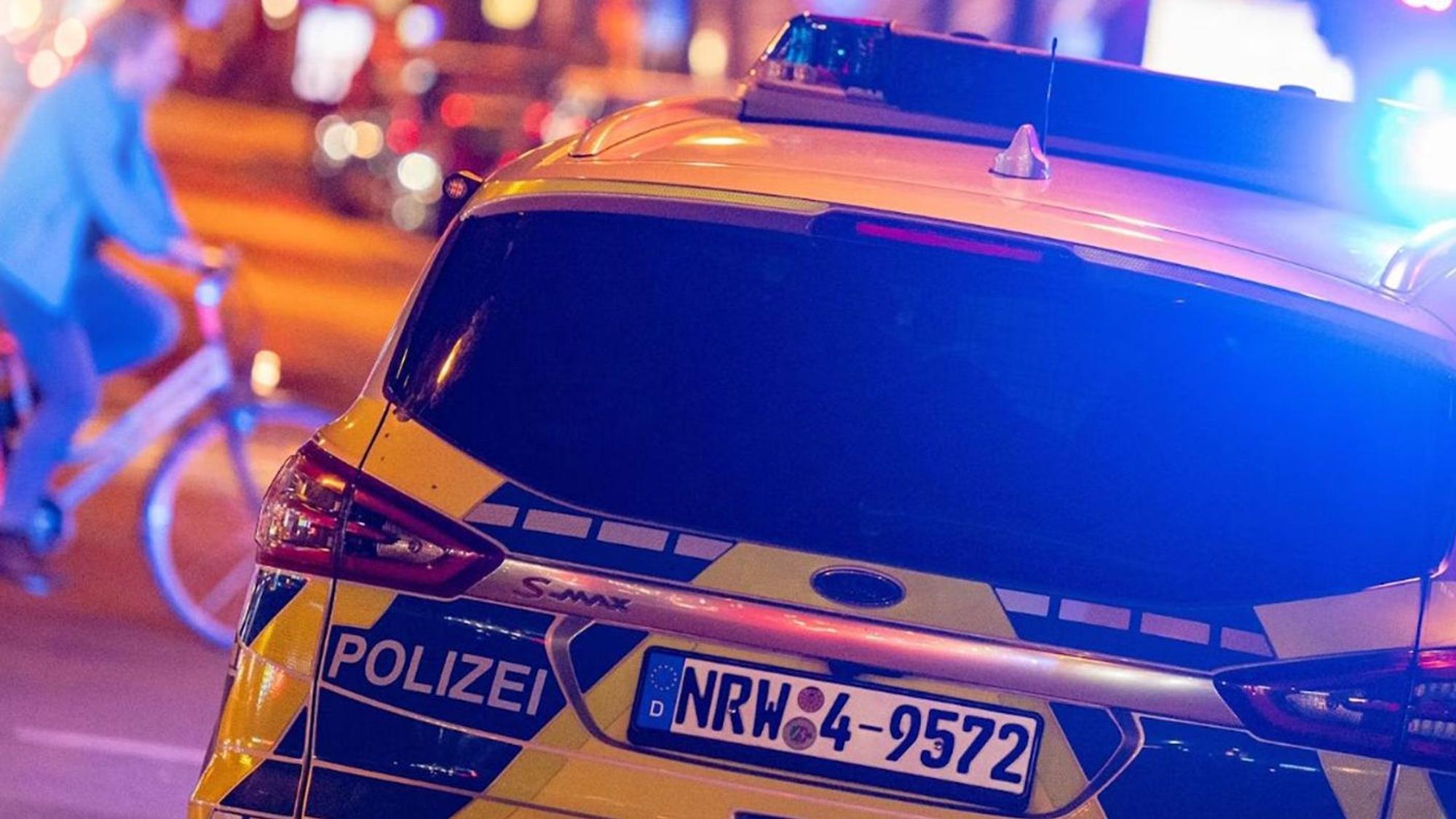 Einsatz der Polizei mit Blaulicht. Fahrradfahrer im Hintergrund.