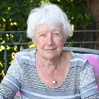 Margot Bäumerich sitzt auf einem Gartenstuhl.