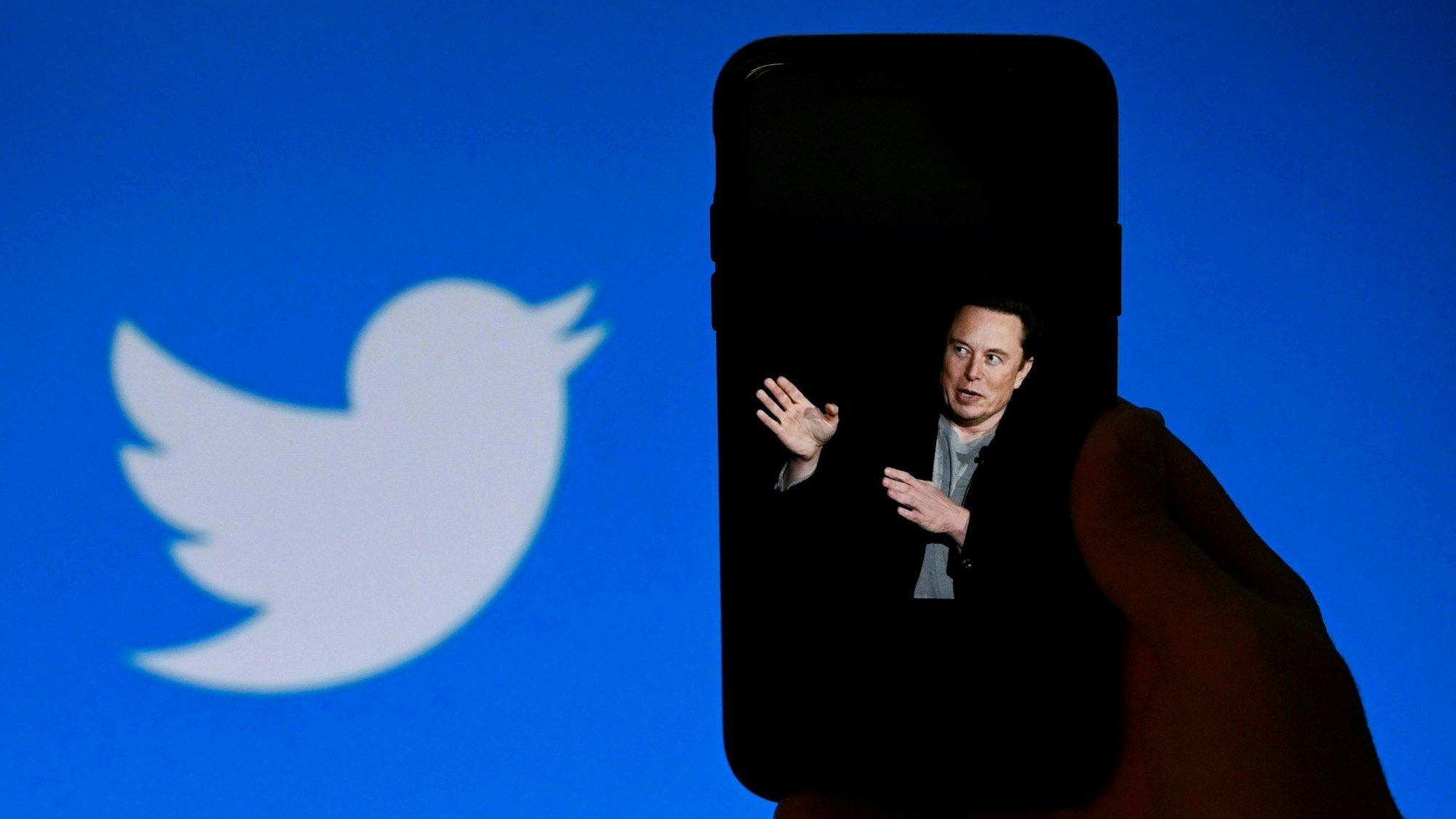 Auf diesem Dateifoto vom 4. Oktober 2022 zeigt ein Telefonbildschirm in Washington, DC, ein Foto von Elon Musk mit dem Twitter-Logo im Hintergrund.