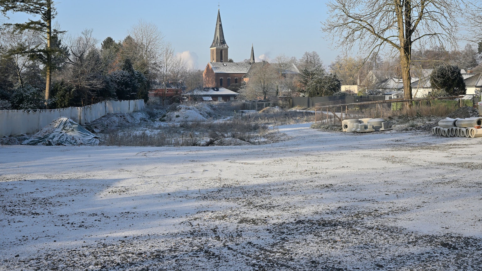 Das Baugrundstück im Schnee, im Hintergrund die Kirche.