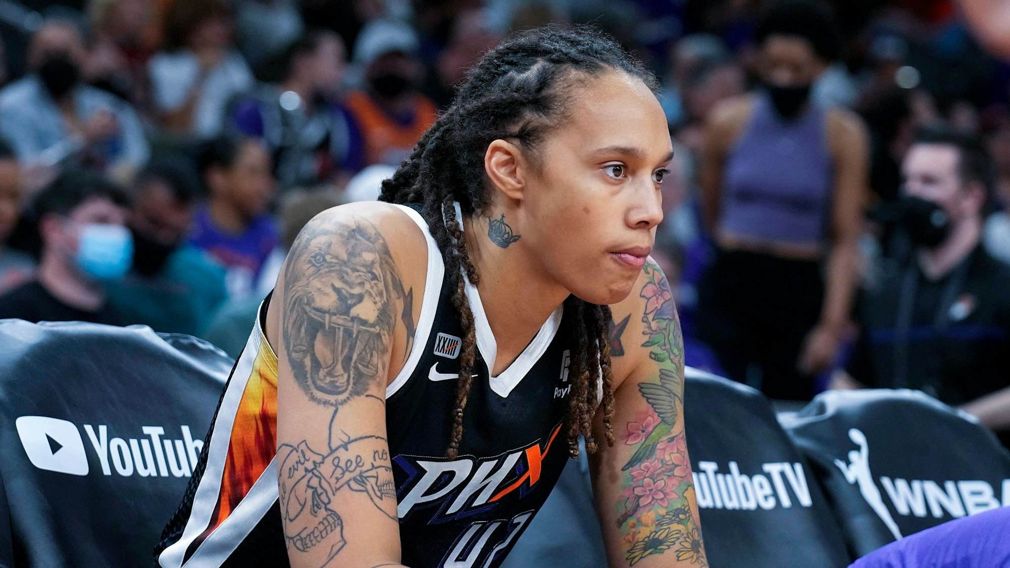 Brittney Griner sitzt während eines Spiels am Rand im Phoenix Mercury Center. Sie schaut ernst.