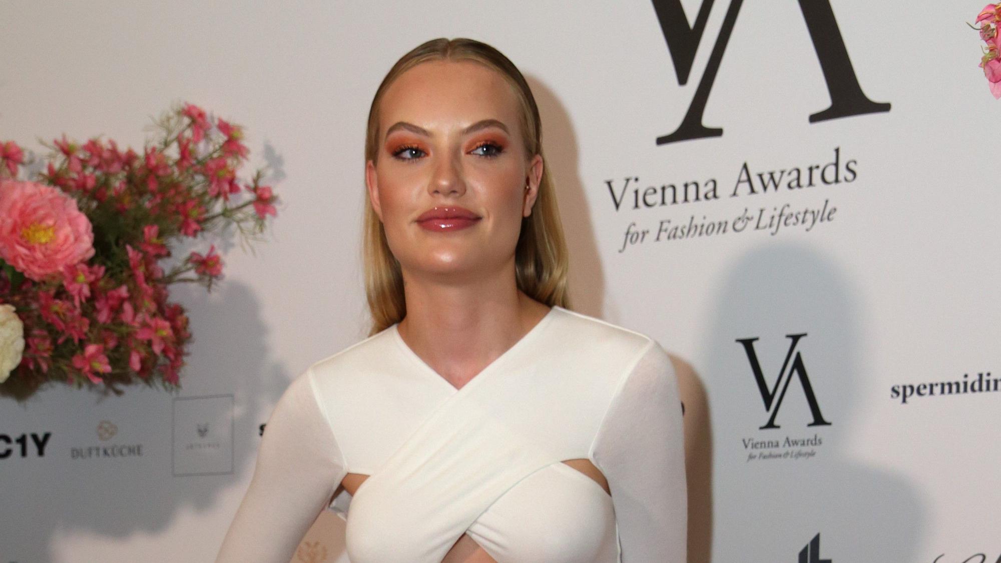 Cheyenne Ochsenknecht posiert für Fotografen in einem weißen Kleid.