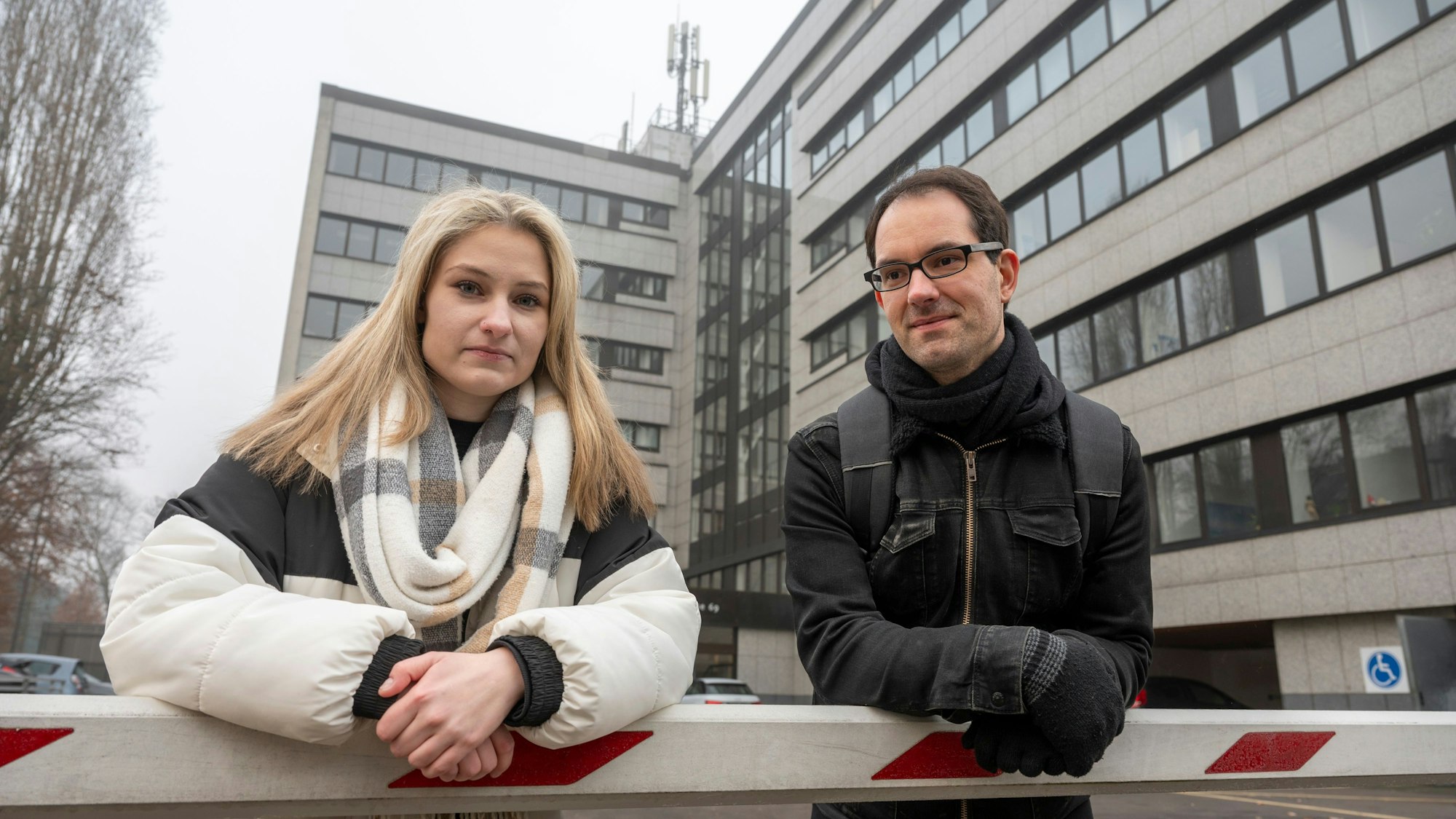 Christin Quenter und Tobias Schmitt stehen vor dem mehrstöckigen Gebäude der DAA-Pflegefachschule in Ehrenfeld.