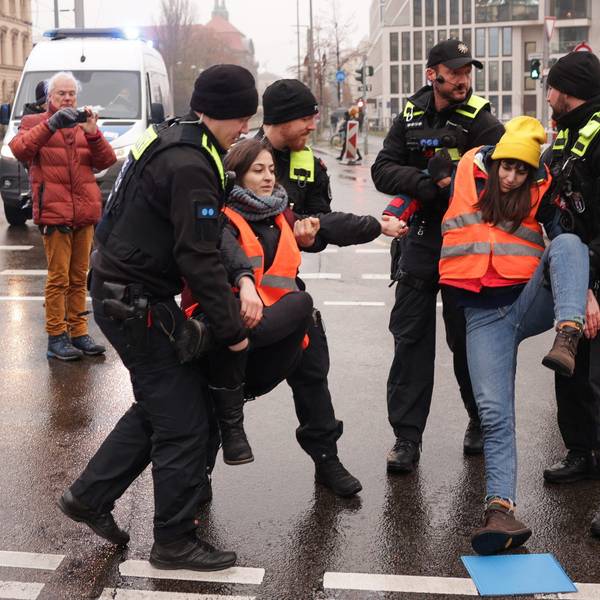 Klimaaktivisten werden von der Invalidenstraße getragen, nachdem sie sich auf dem Asphalt festgeklebt hatten.