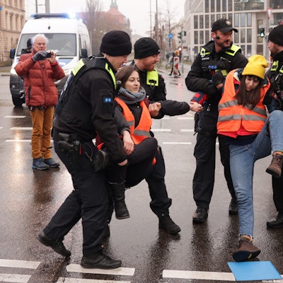 Klimaaktivisten werden von der Invalidenstraße getragen, nachdem sie sich auf dem Asphalt festgeklebt hatten.