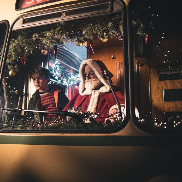 Der Weihnachtsmann und ein Junge sitzen zusammen in der Fahrerkabine einer historischen Stadtbahn der KVB.