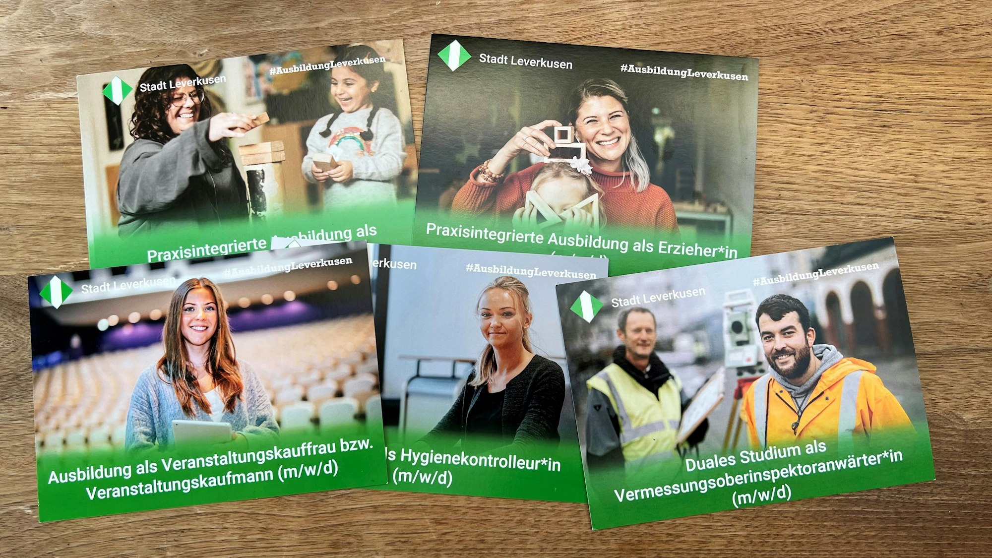 Postkarten mit Stadtlogo und Porträts von fröhlichen Mitarbeitenden