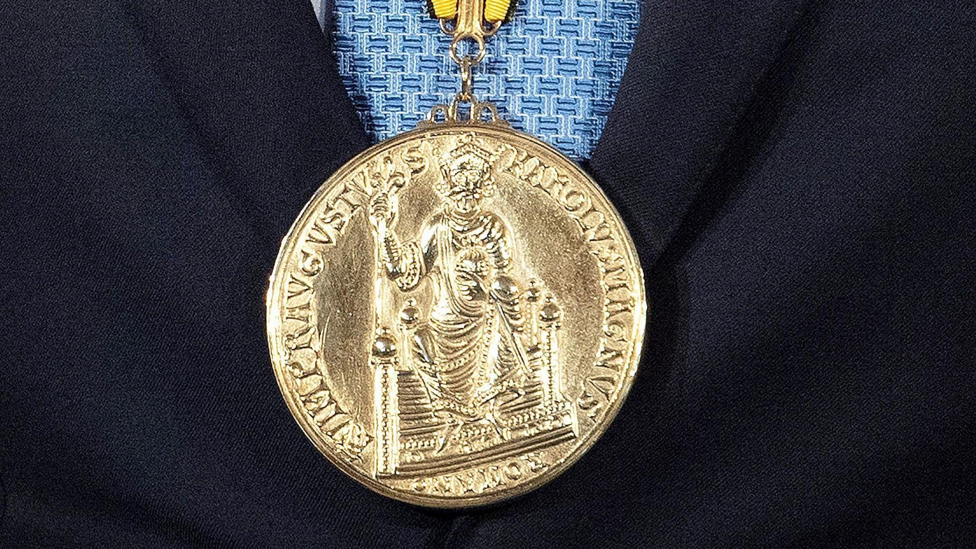 Die goldene Karlspreis-Medaille hängt während der Verleihung 2021 am Hals von Klaus Iohannis, Präsident von Rumänien.