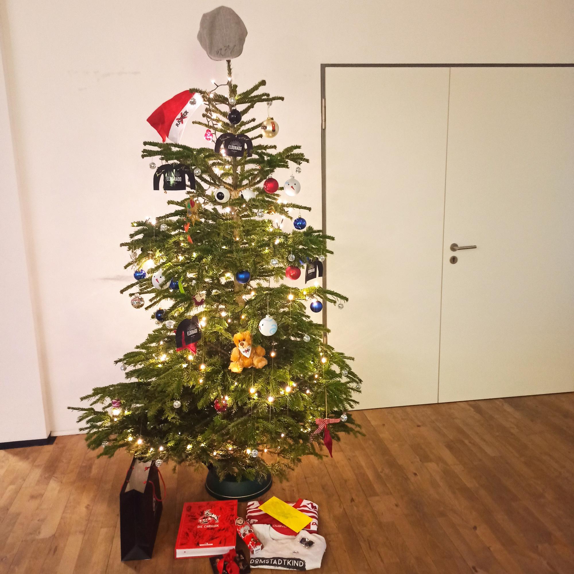 Der geschmückter Weihnachtsbaum mit der Schiebermütze auf der Spitze.
