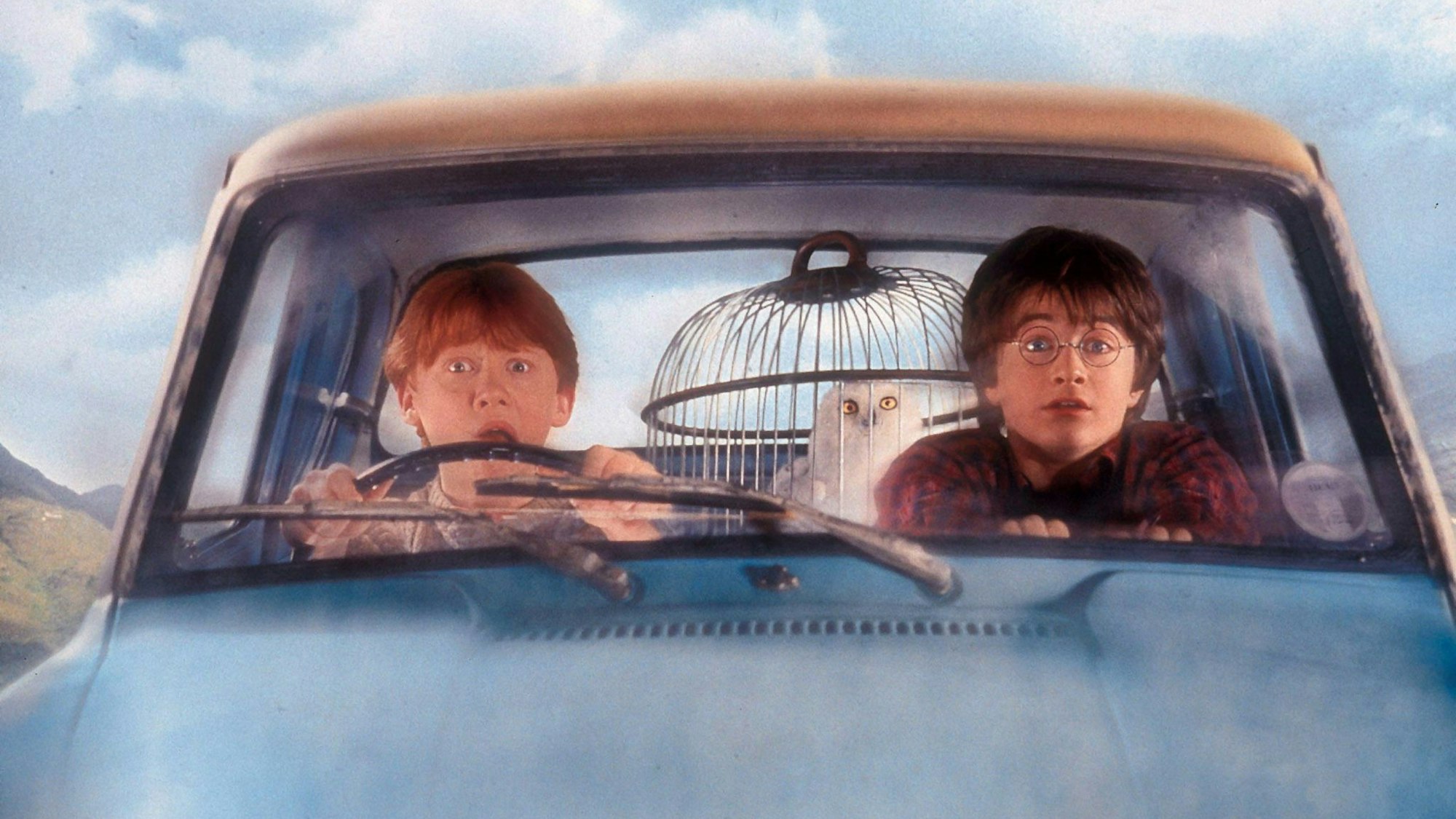 Harry Potter, Ron Weasley und die Eule Hedwig sitzen in Mr. Weasley’s fliegendem Auto, einem Ford Anglia.