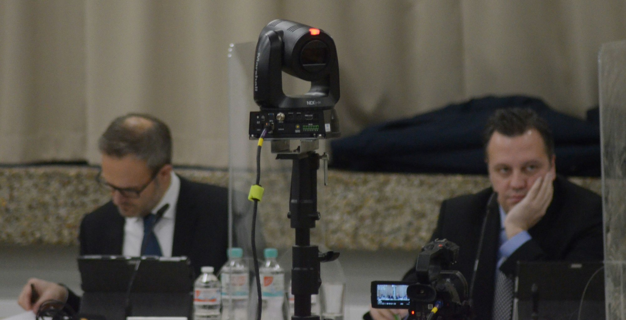 Eine Kamera überträgt aus dem Ratssaal, im Hintergrund sind Bürgermeister Sacha Reichelt und der Technische Beigeordnete Wolfgang Honecker zu sehen.