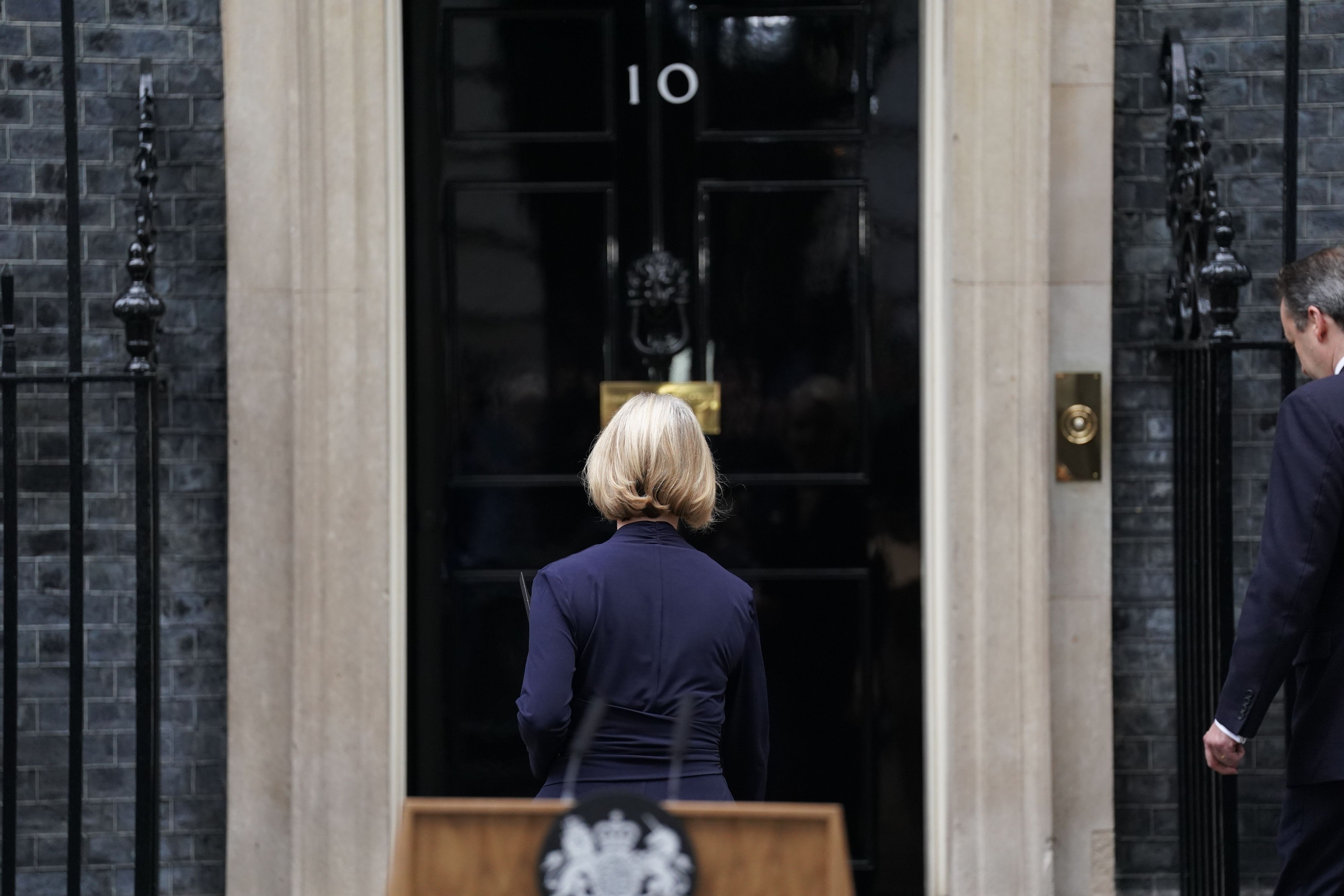 Liz Truss an der Downing Street, sie steht mit dem Rücken zur Kamera.