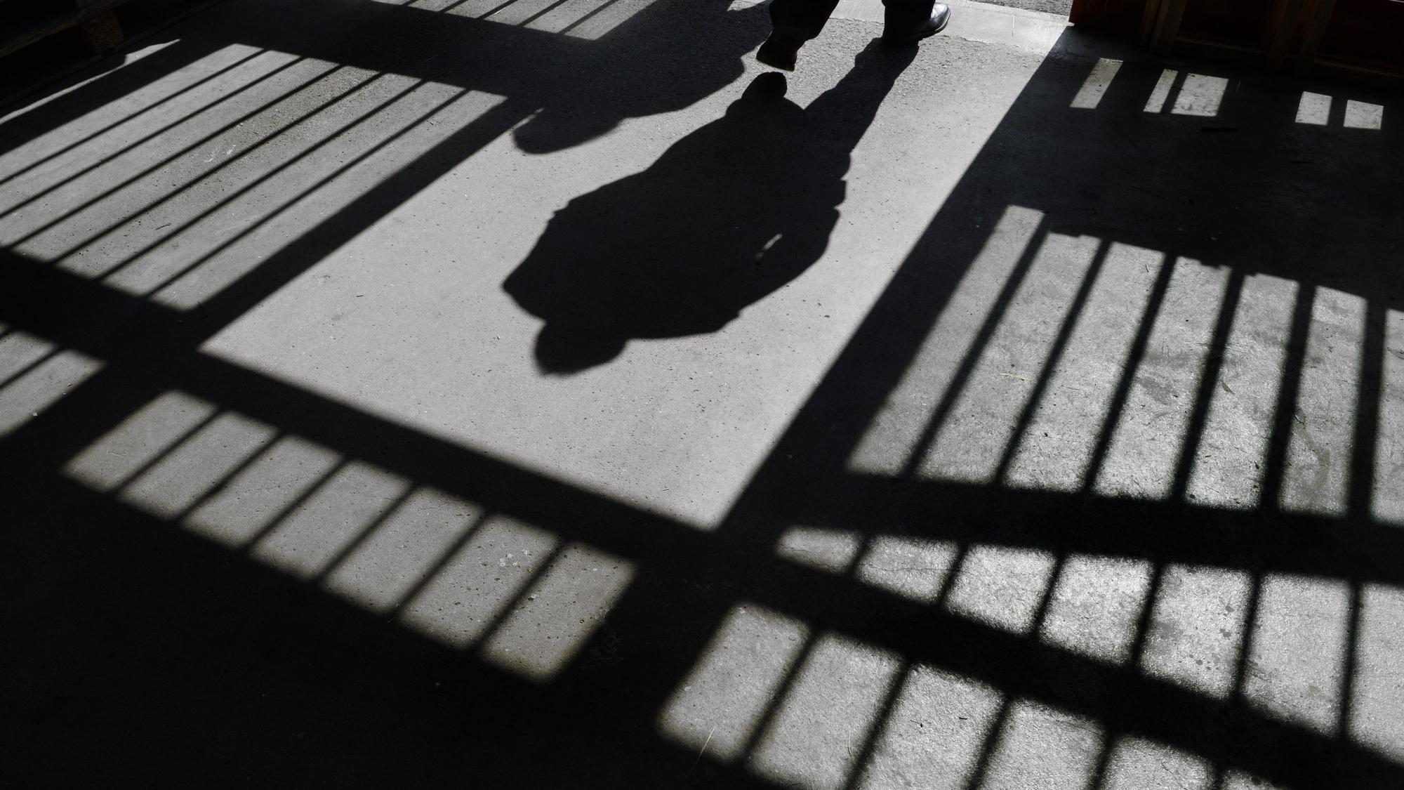 Es sind der Schatten von einem Mensch und von Gitterstäben zu sehen.