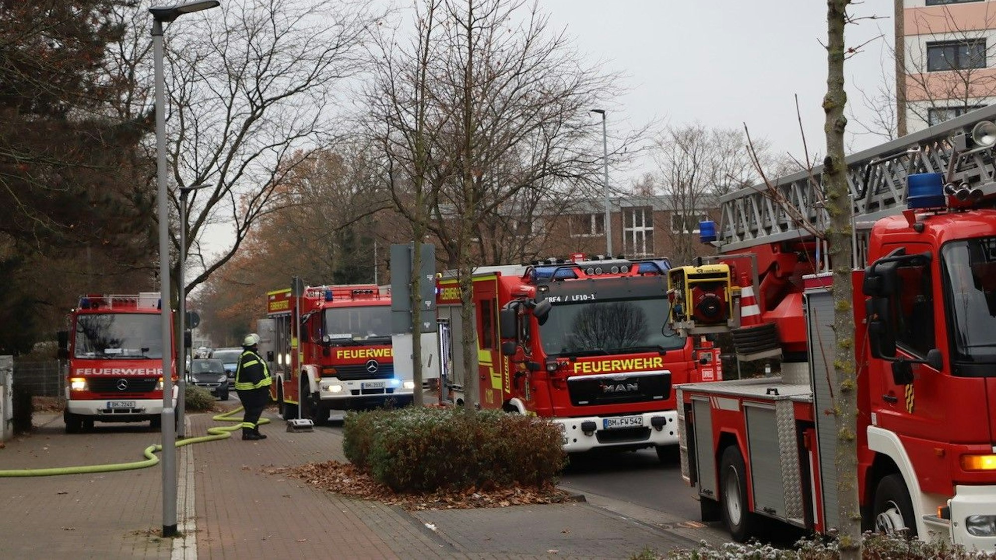 Feuerwehrwagen stehen während eines Einsatzes in Erftstadt am Straßenrand.