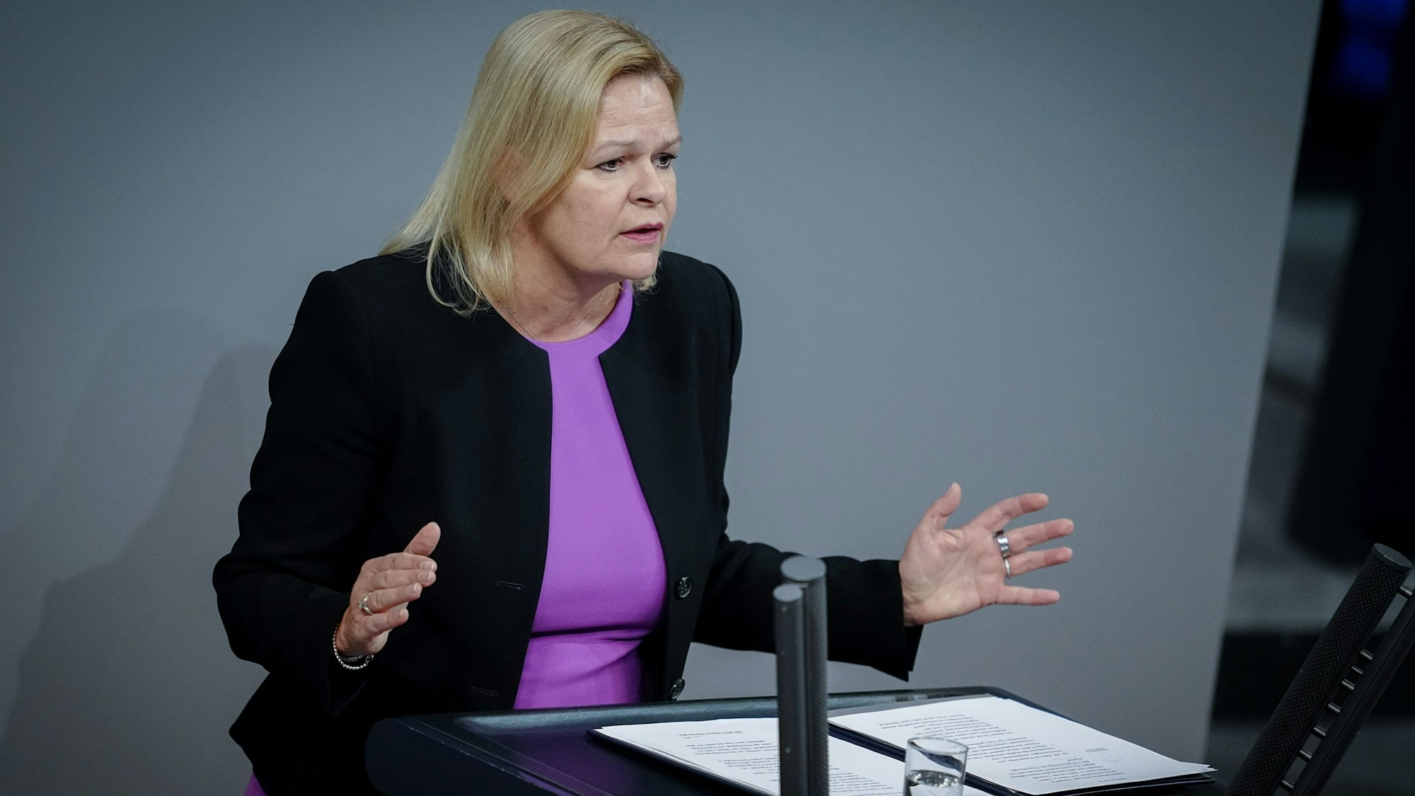 Es ist Nancy Faeser vor einem Podium zu sehen.