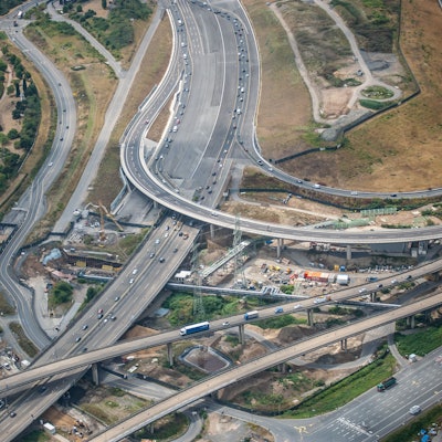 Eine Luftaufnahme zeigt Autobahn und  Autobahnkreuz Leverkusen: viele graue Bänder durchziehen das Bild.