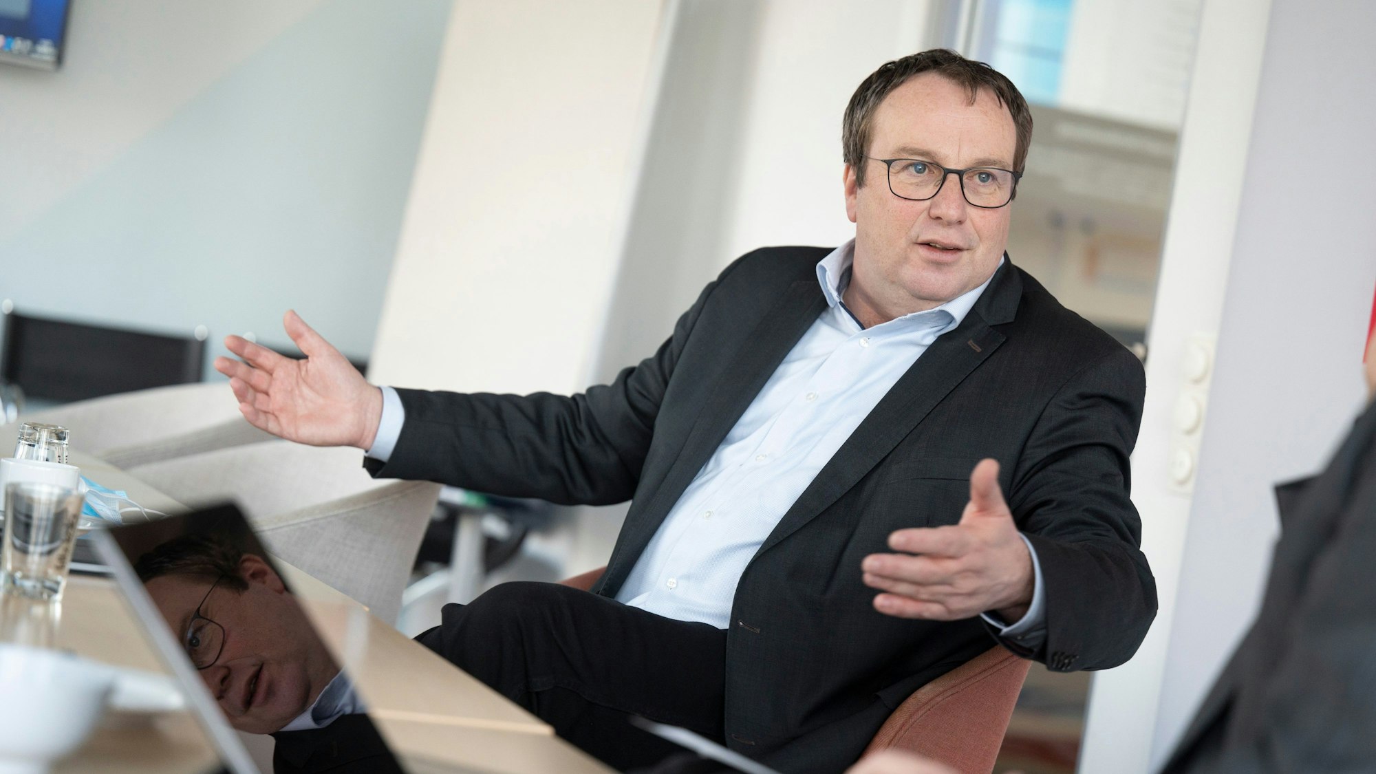 NRW-Verkehrsminister Oliver Krischer breitet im Gespräch die Hände aus.