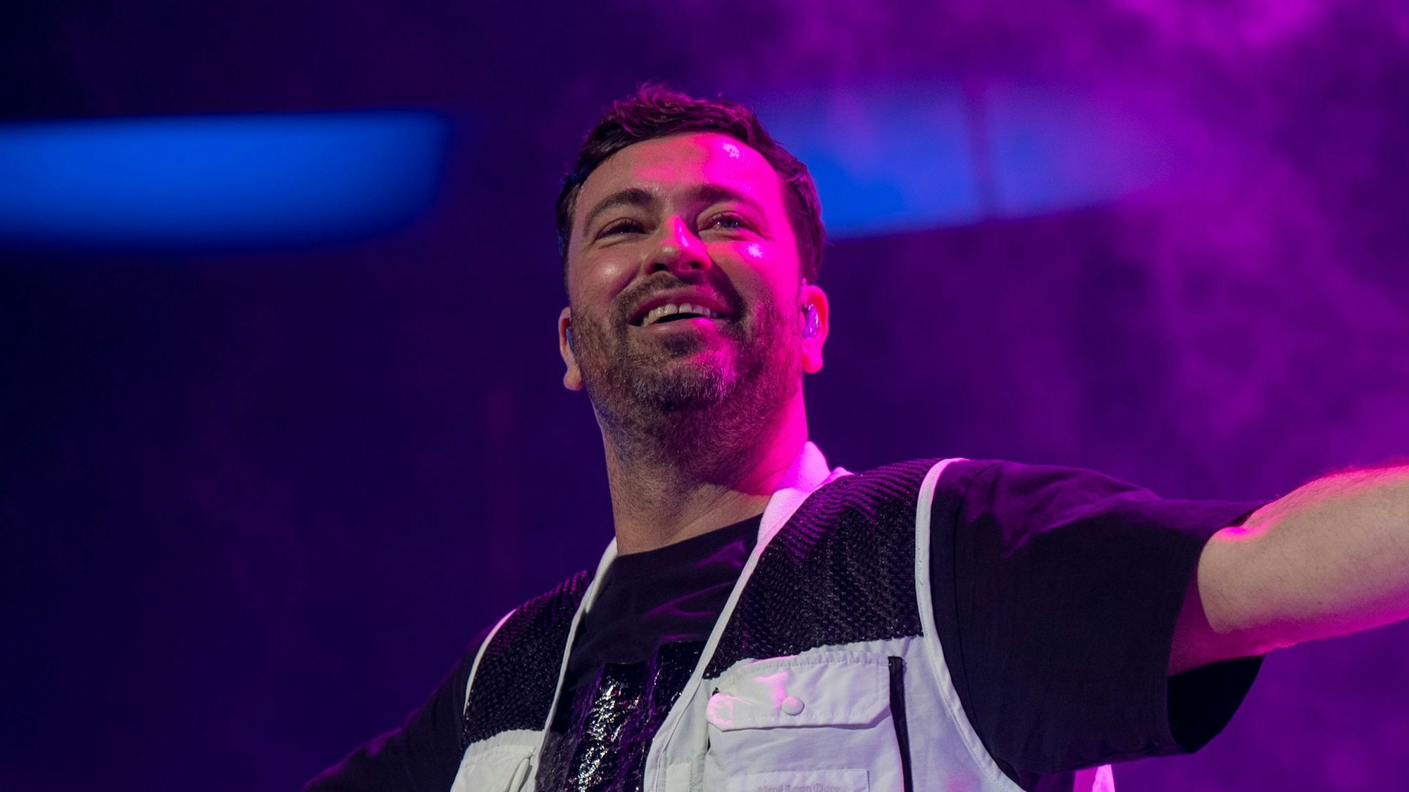 Marteria steht mit ausgebreiteten Armen auf der Bühne.