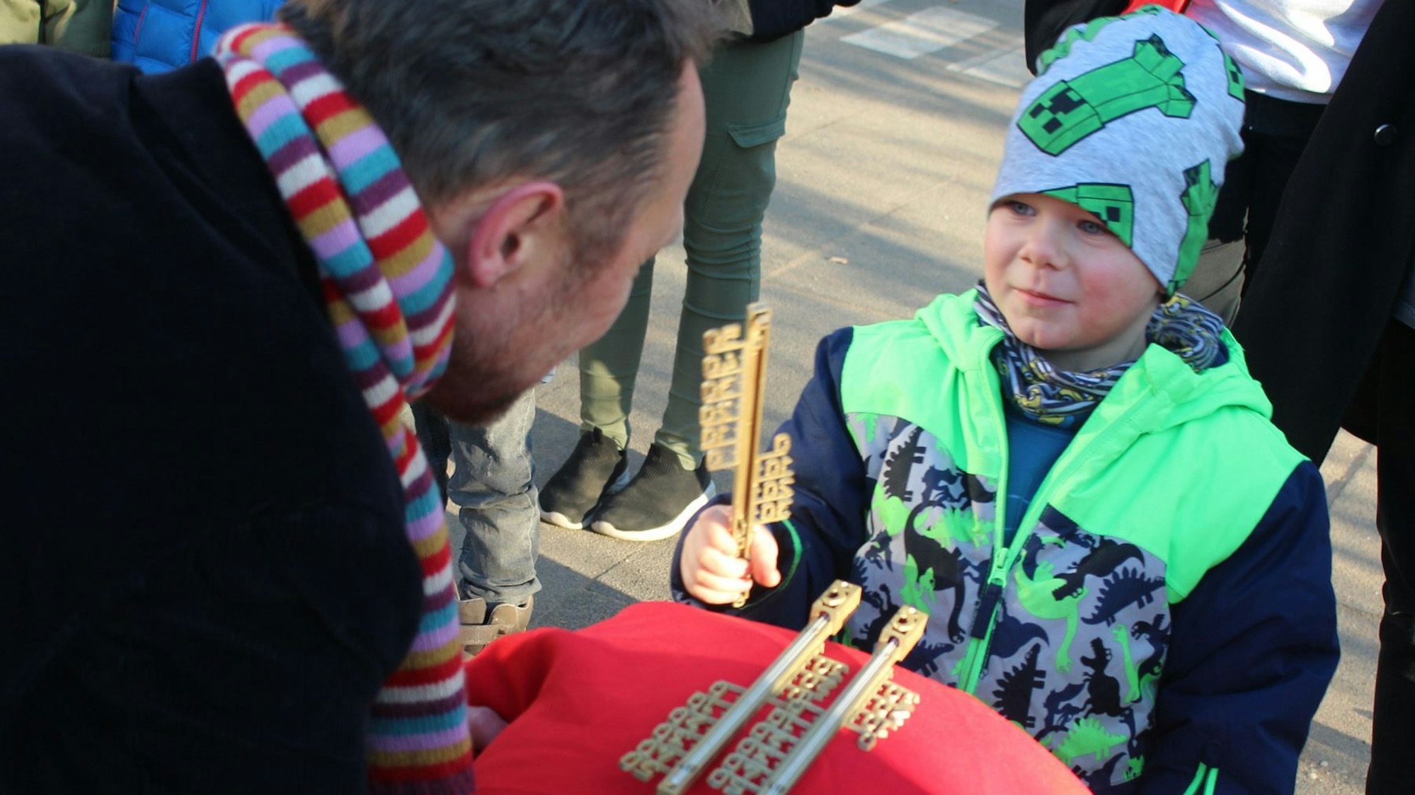 Der kleine Meilo steht vor dem Oberbürgermeister, der ihm auf dem Naturgut Ophoven gerade ein Goldenes Thermometer überreicht hat.