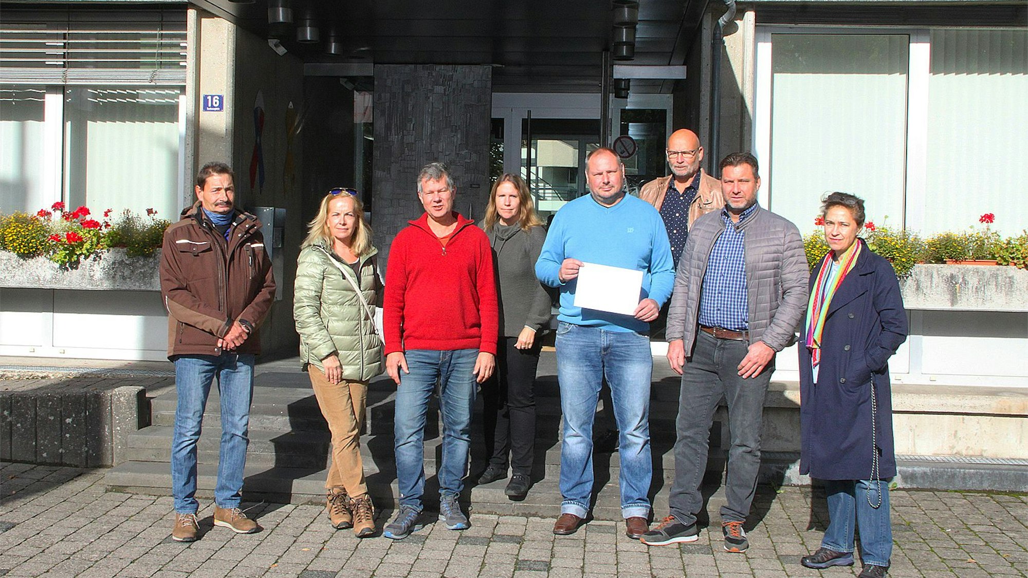 Bürgerinnen und Bürger von Blankenheim stehen mit dem Anmeldebogen des Bürgerbescheides vor dem Rathaus.