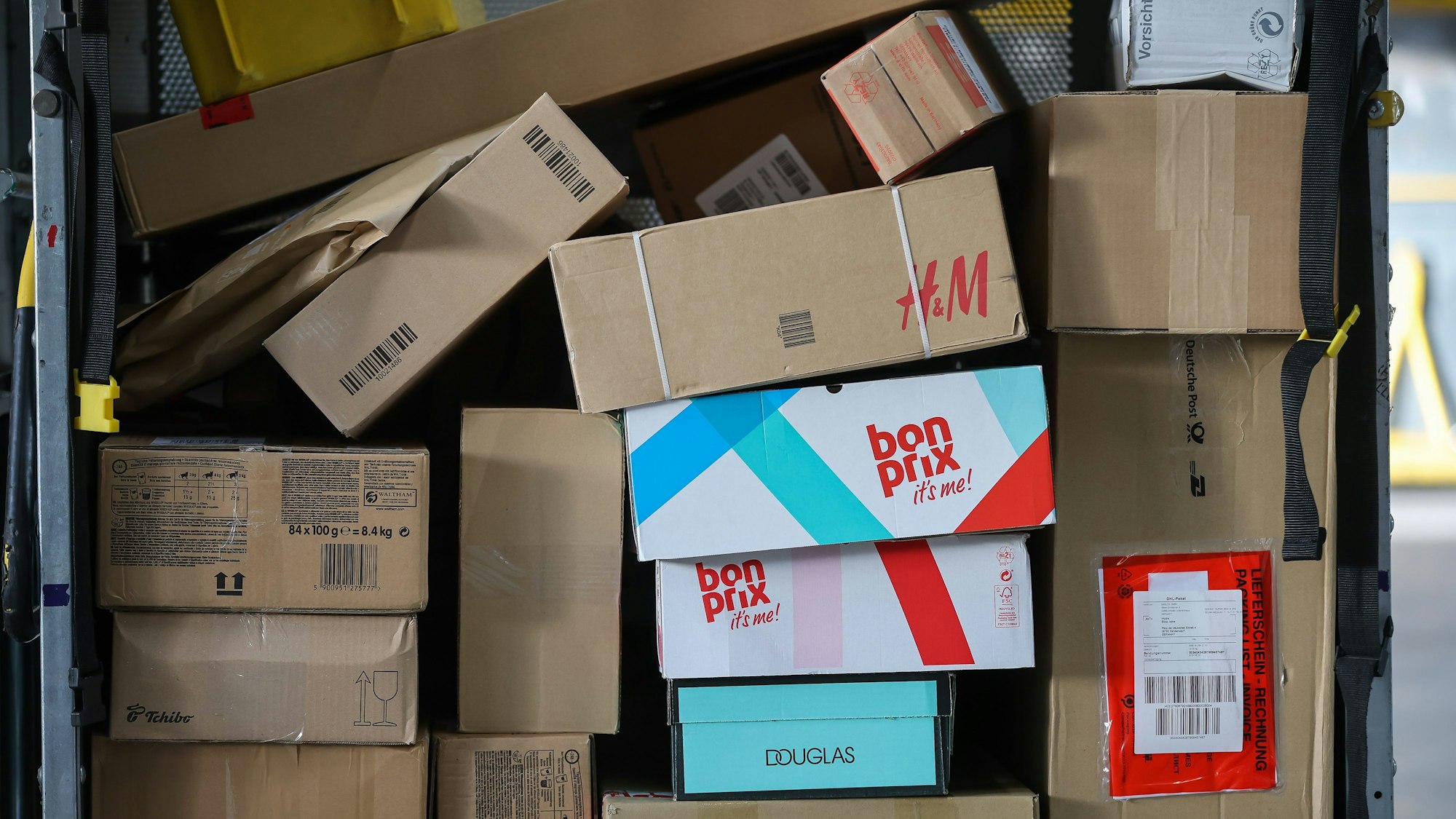 Ein Paketwagen steht voll mit Paketen in einem Zustellpunkt.