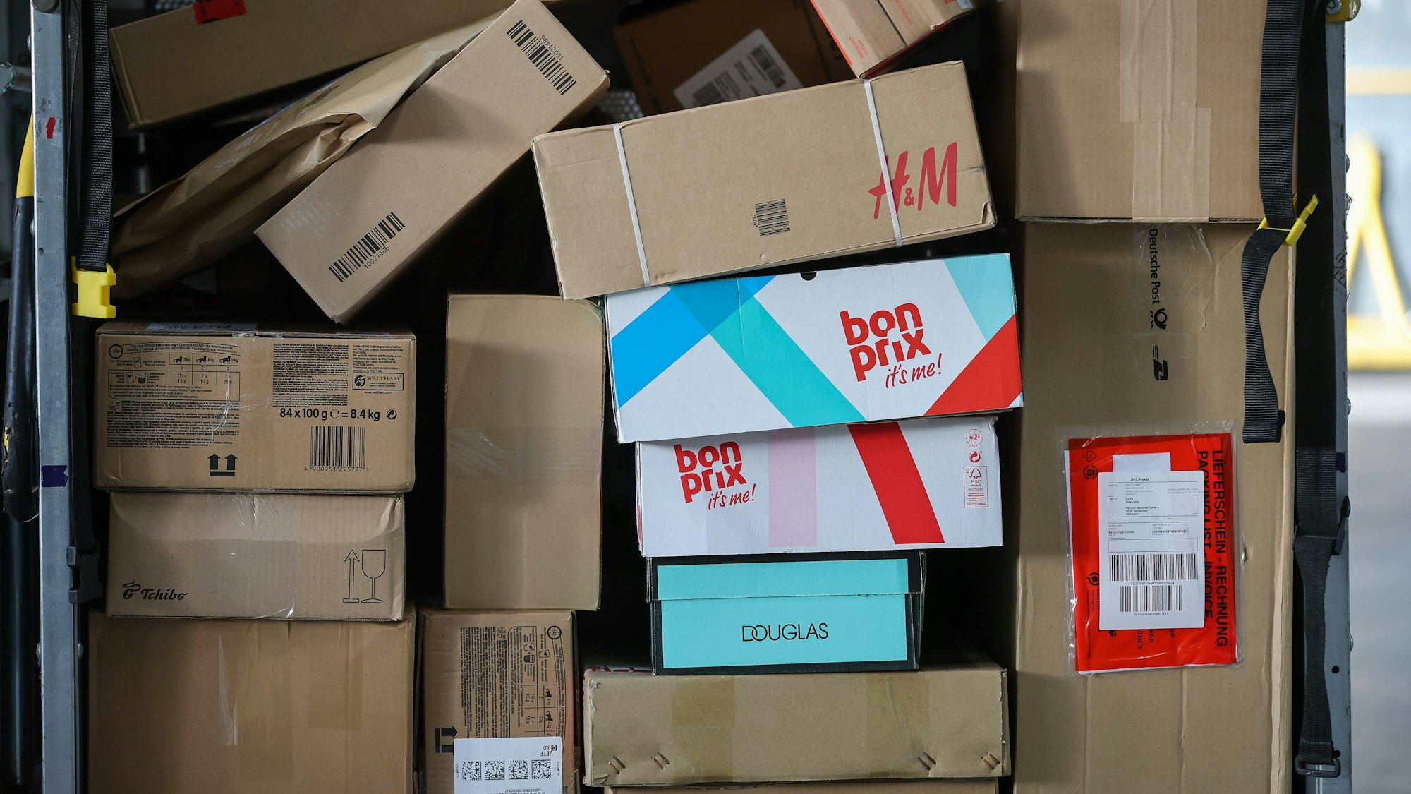 Ein Paketwagen steht voll mit Paketen in einem Zustellpunkt.