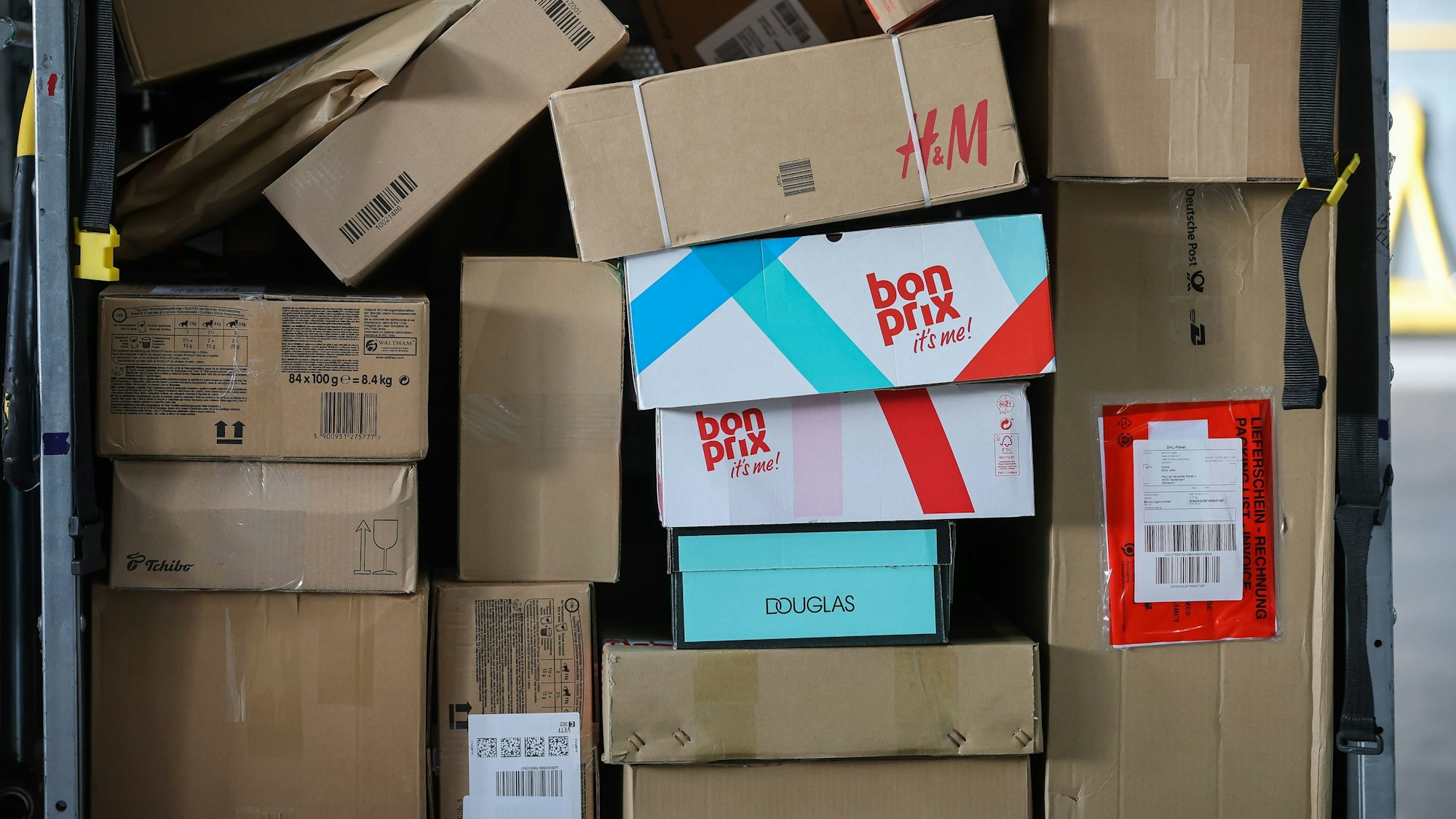 Ein Paketwagen steht voll mit Paketen in einem Zustellpunkt.