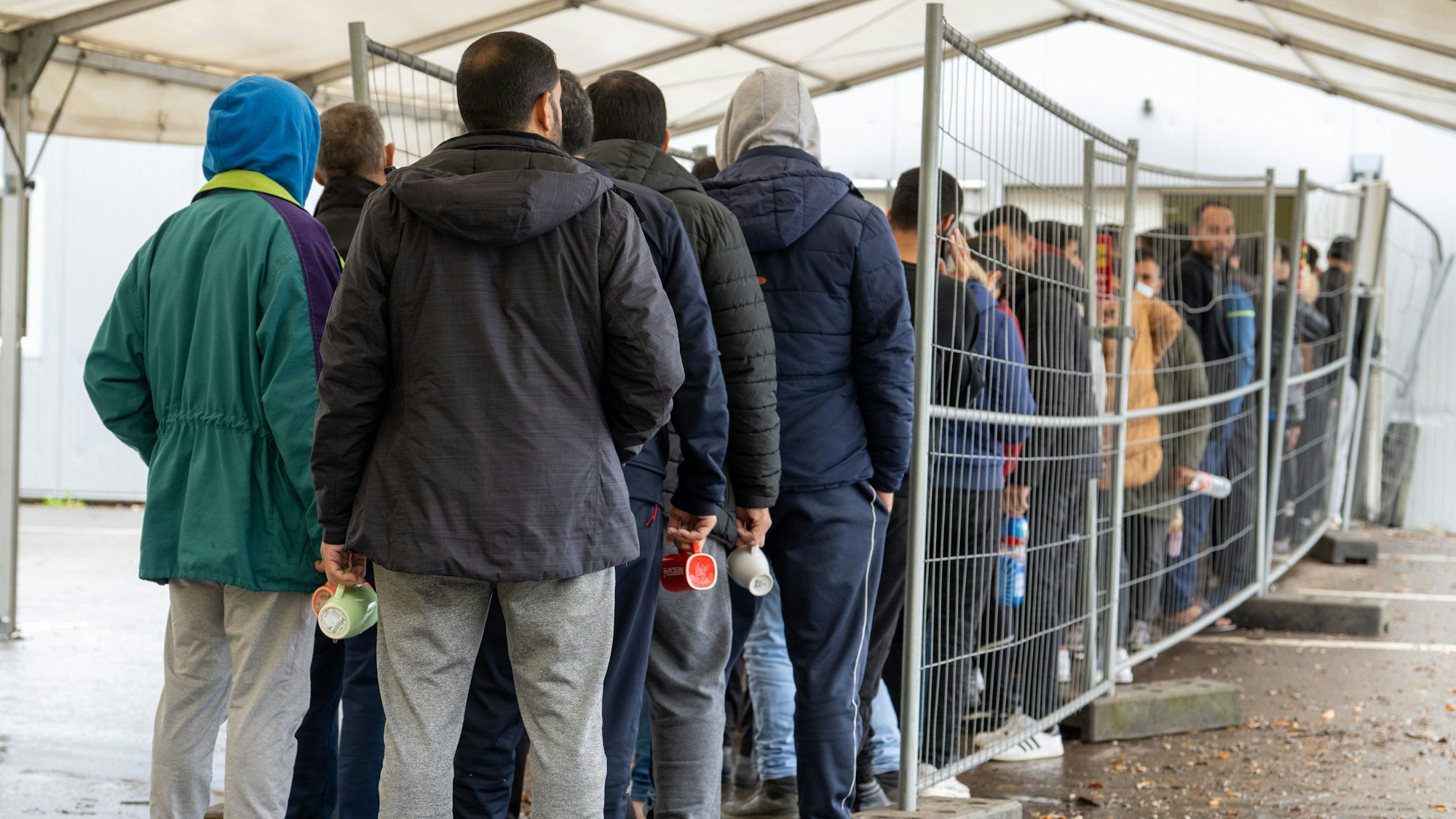 In der Landeserstaufnahmestelle in Ellwangen warten Flüchtlinge in einer Schlange vor der Essensausgabe.
