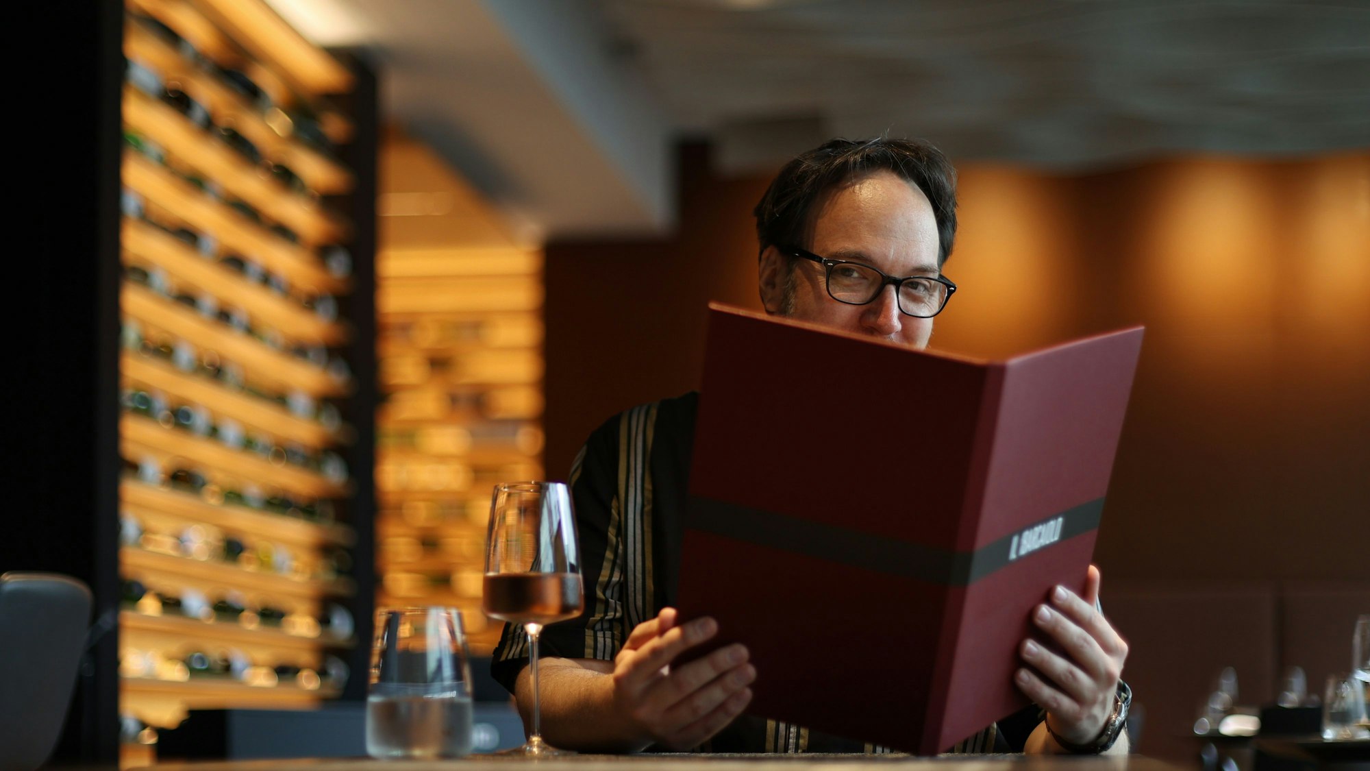 Mann mit Brille schaut in eine Speisekarte