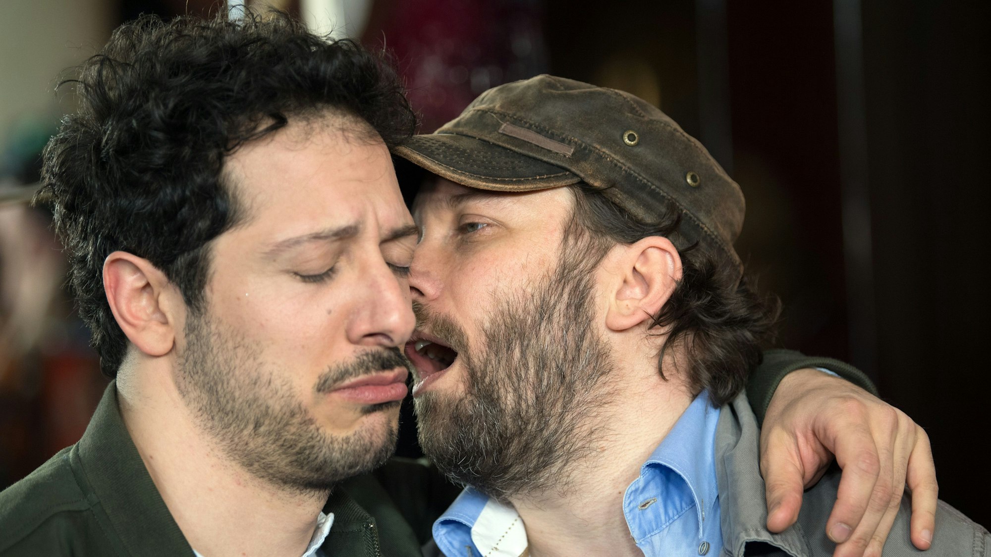 21.03.2018, Berlin: Die Schauspieler Christian Ulmen (l) und Fahri Yardim kommen zur Premiere der Maxdome/ProSieben-Serie „jerks“ in den Zoopalast. Ulmen hat den Mund geöffnet und ist nah an Yardims Ohr. Yardim guckt traurig.