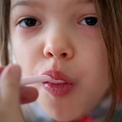 Ein Kind bekommt ein Medikament mit einem Löffel verabreicht. Wenn das Kind Fieber hat, sind in vielen Familien Fiebersäfte erste Wahl. Aber die sind derzeit schwer zu bekommen.