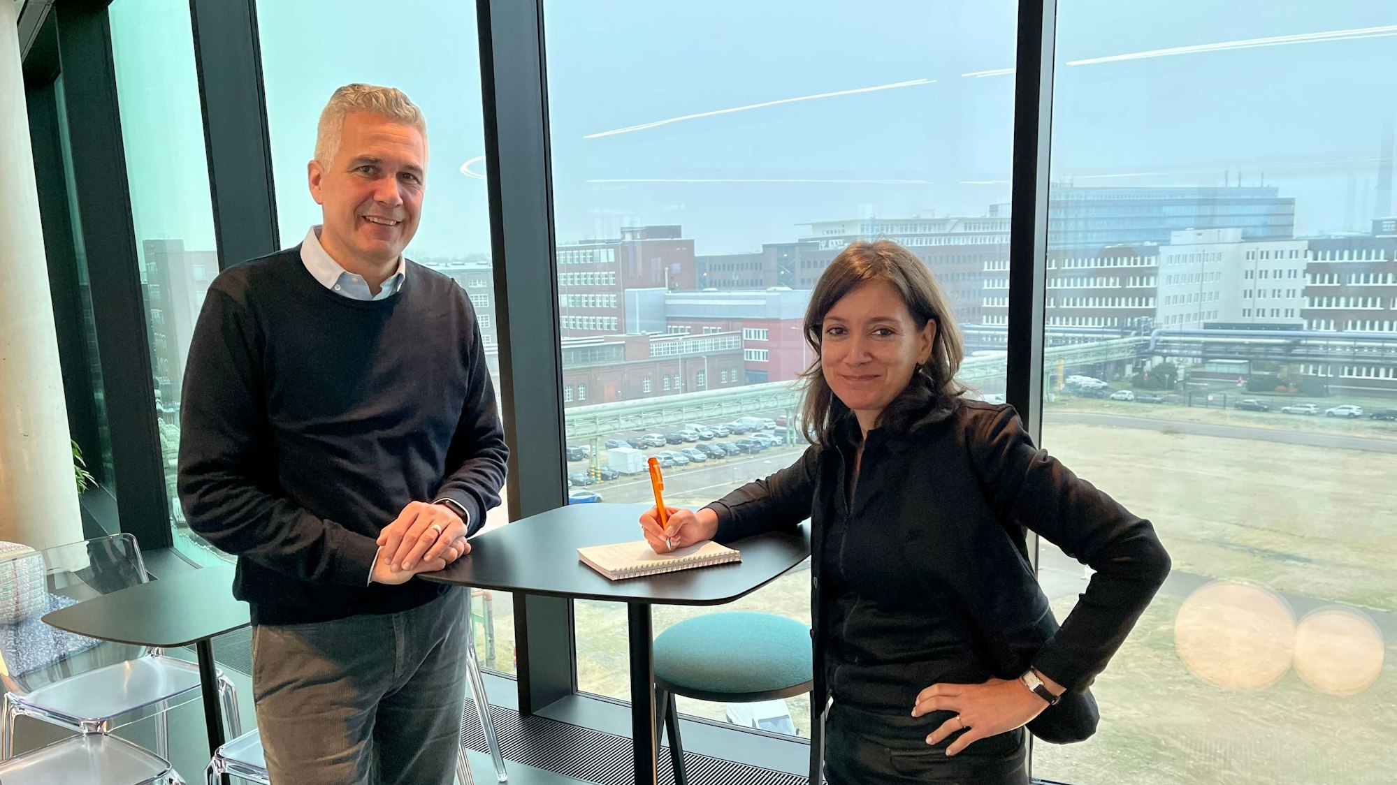 Thomas Adenauer, Projektleiter für die neue Covestro-Zentrale, steht mit Céline Bélujon, Change-Managerin in der Personalabteilung, an einem Tisch mit Blick in den Chempark