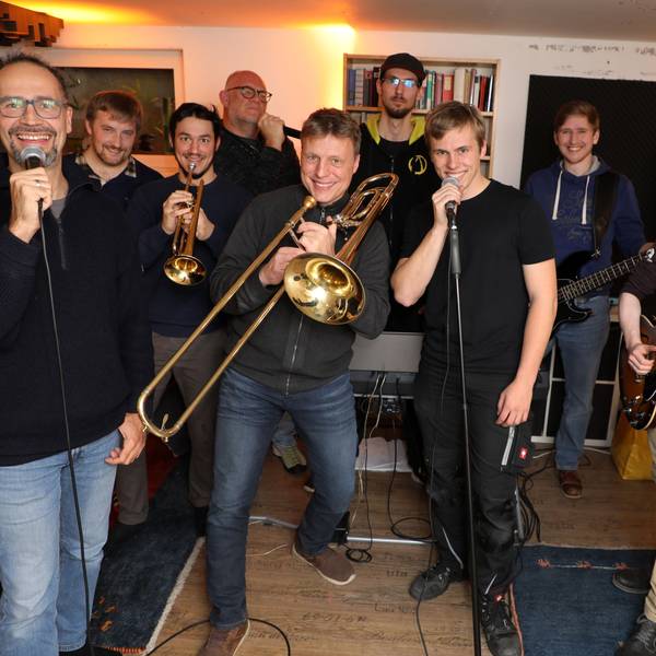 Die Band steht beisammen und posiert für die Kamera.
